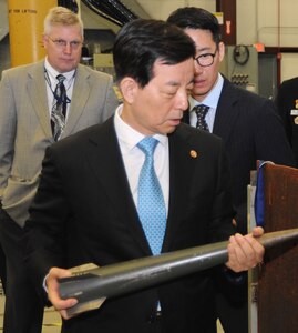 Republic of Korea (ROK) Minister of National Defense Han Min-koo – who led the ROK delegation to see new and emerging technologies developed at Naval Surface Warfare Center Dahlgren Division (NSWCDD) – holds an electromagnetic railgun projectile and inspects damage caused to metal plates from a previous test. NSWCDD engineers briefed Han and his delegation on electromagnetic launchers, hypervelocity projectiles, and directed energy weapons, in addition to the command’s core capabilities in complex warfare systems development and integration to incorporate electric weapons technology into existing and future fighting forces and platforms.
