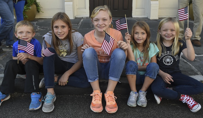 Nolan Milton, Sophie Brown, Alice Milton, Ellie Brown and Anna Milton (left to right) wave their flags while watching the Veterans Day parade in Charleston, South Carolina, Oct. 6, 2016. Veterans Day began on Armistice Day, Nov. 11, 1919, which was the first anniversary of the end of World War I. 