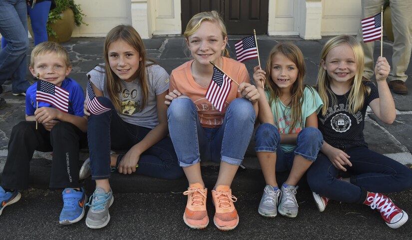 Nolan Milton, Sophie Brown, Alice Milton, Ellie Brown and Anna Milton (left to right) wave their flags while watching the Veterans Day parade in Charleston, South Carolina, Oct. 6, 2016. Veterans Day began on Armistice Day, Nov. 11, 1919, which was the first anniversary of the end of World War I. 
