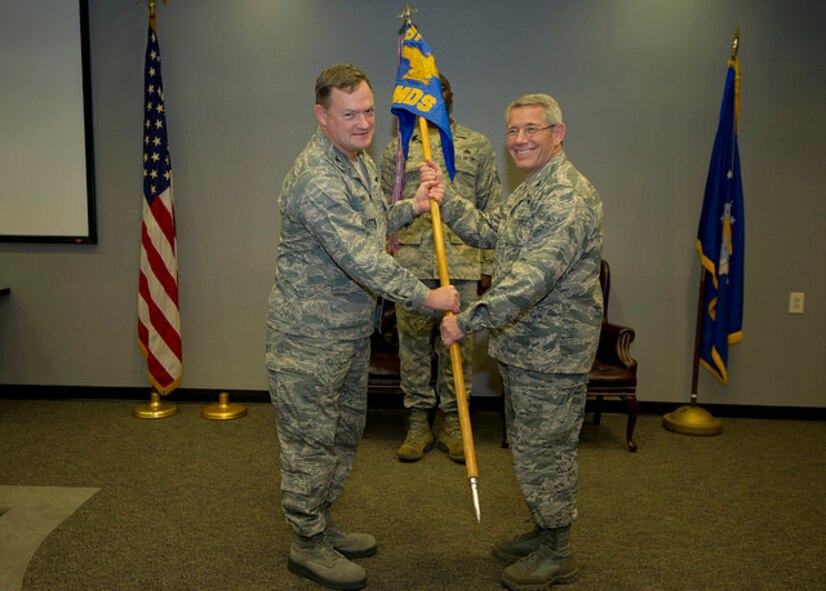 Col. David Pavey, 514th Air Mobility Wing commander, passes the 514th Aerospace Medicine Squadron's guidon to Col. Joseph Matson, who assumed command of the squadron during an assumption of command ceremony here, Nov. 11.