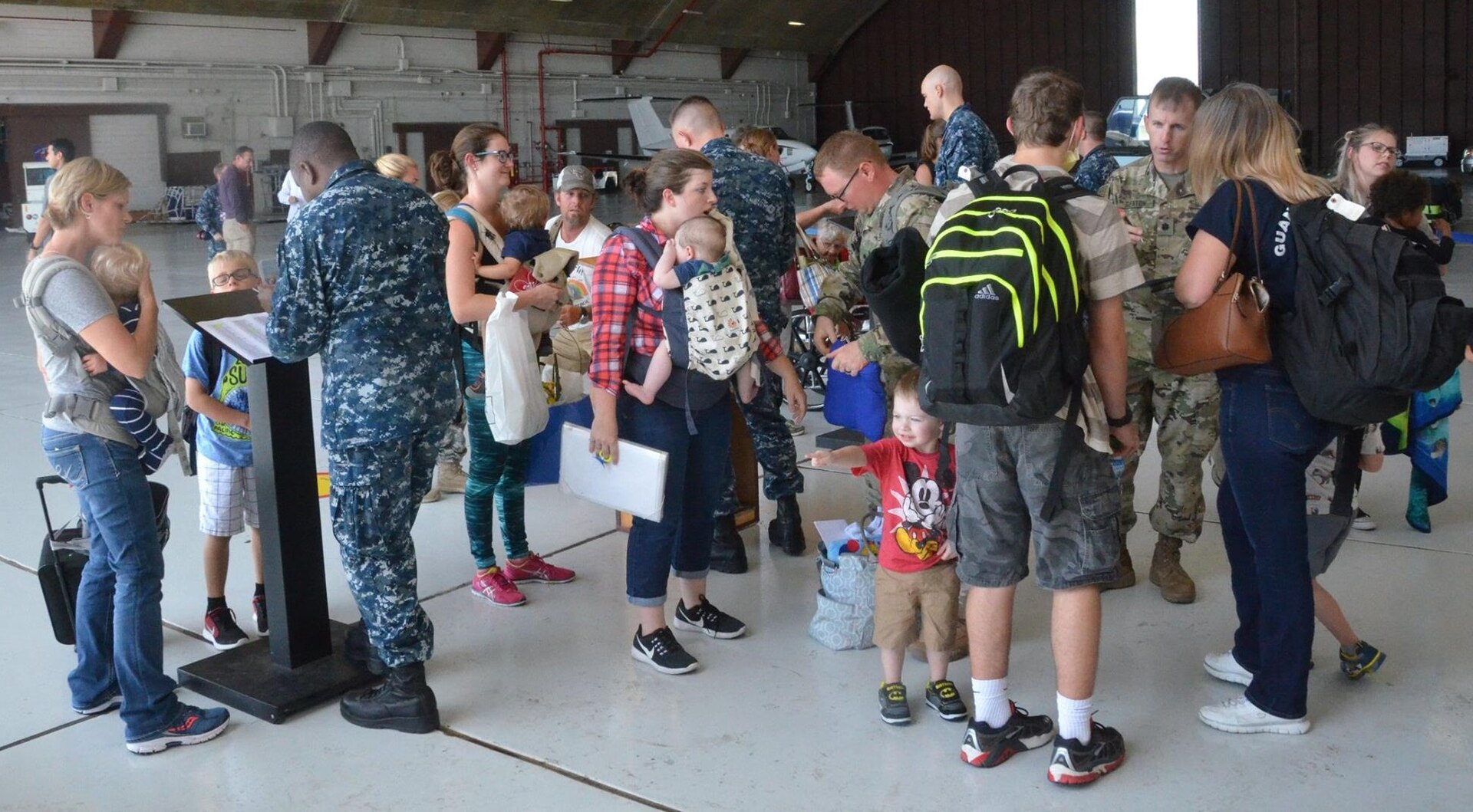 Naval Station Guantanamo Bay, or NSGB, Cuba, families check in at the air terminal Oct. 11 during their return after having been evacuated to Naval Air Station Pensacola, Fla., due to Hurricane Matthew.