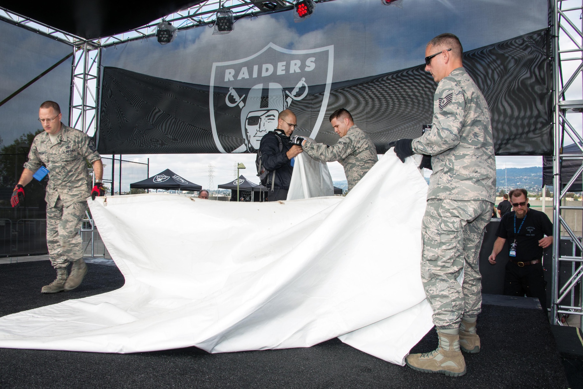 Members of the Air Force Band of the Golden West’s rock group “Mobility” prepare the stage for their halftime show performance for the Oakland Raiders Salute to Service game against the Denver Broncos at the Oakland Coliseum in Oakland Calif., Nov 6, 2016. The band is stationed at Travis Air Force Base, Calif., and performed to a live audience of more than 54,000 fans. The band’s performing groups advance Air Mobility Command and global Air Force missions by providing professional musical products and services for official military, recruiting and community relations events. (U.S. Air Force photo/Louis Briscese)
