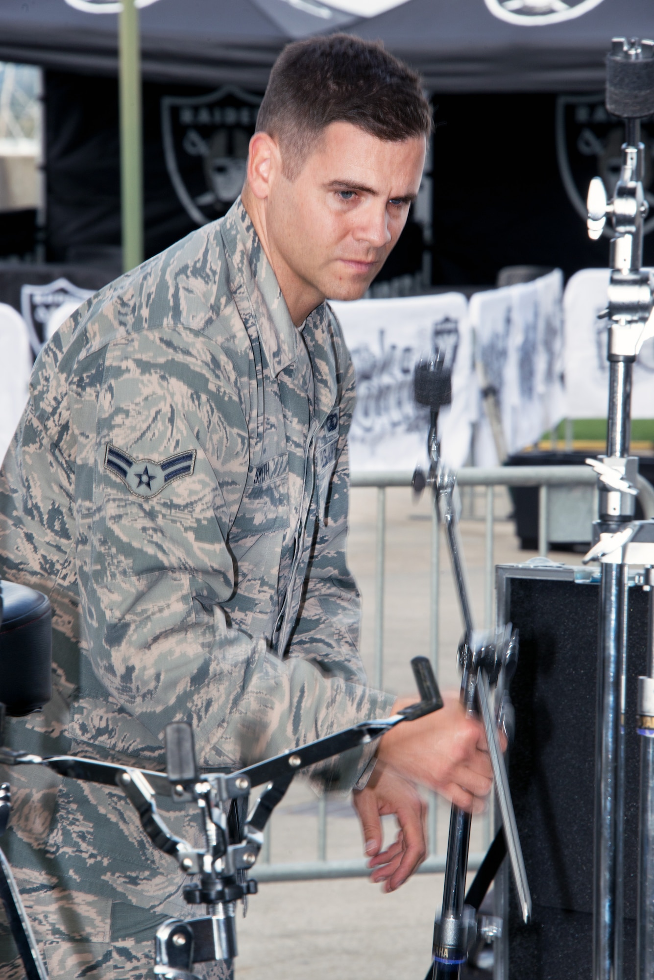 Airman 1st Class Bryan Smith, Air Force Band of the Golden West, sets up his drums before performing during the halftime show of the Oakland Raiders Salute to Service game against the Denver Broncos at the Oakland Coliseum in Oakland Calif., Nov 6, 2016. The band is stationed at Travis Air Force Base, Calif., and performed to a live audience of more than 54,000 fans. The band’s performing groups advance Air Mobility Command and global Air Force missions by providing professional musical products and services for official military, recruiting and community relations events. (U.S. Air Force photo/Louis Briscese)