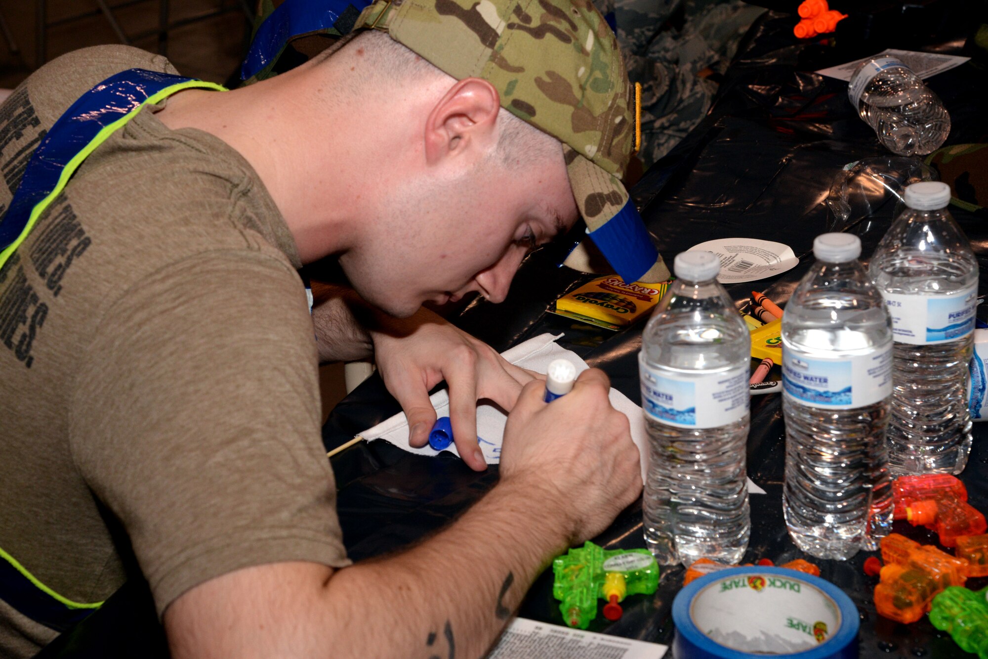 A Maxwell Combat Dining-In attendee designs his team’s flag during the event, Nov. 4, 2016, Maxwell Air Force Base, Ala. Each individual team brainstormed and executed a design for their team as well as a team name. This served as the first challenge of the night. (U.S. Air Force/ Senior Airman Alexa Culbert)