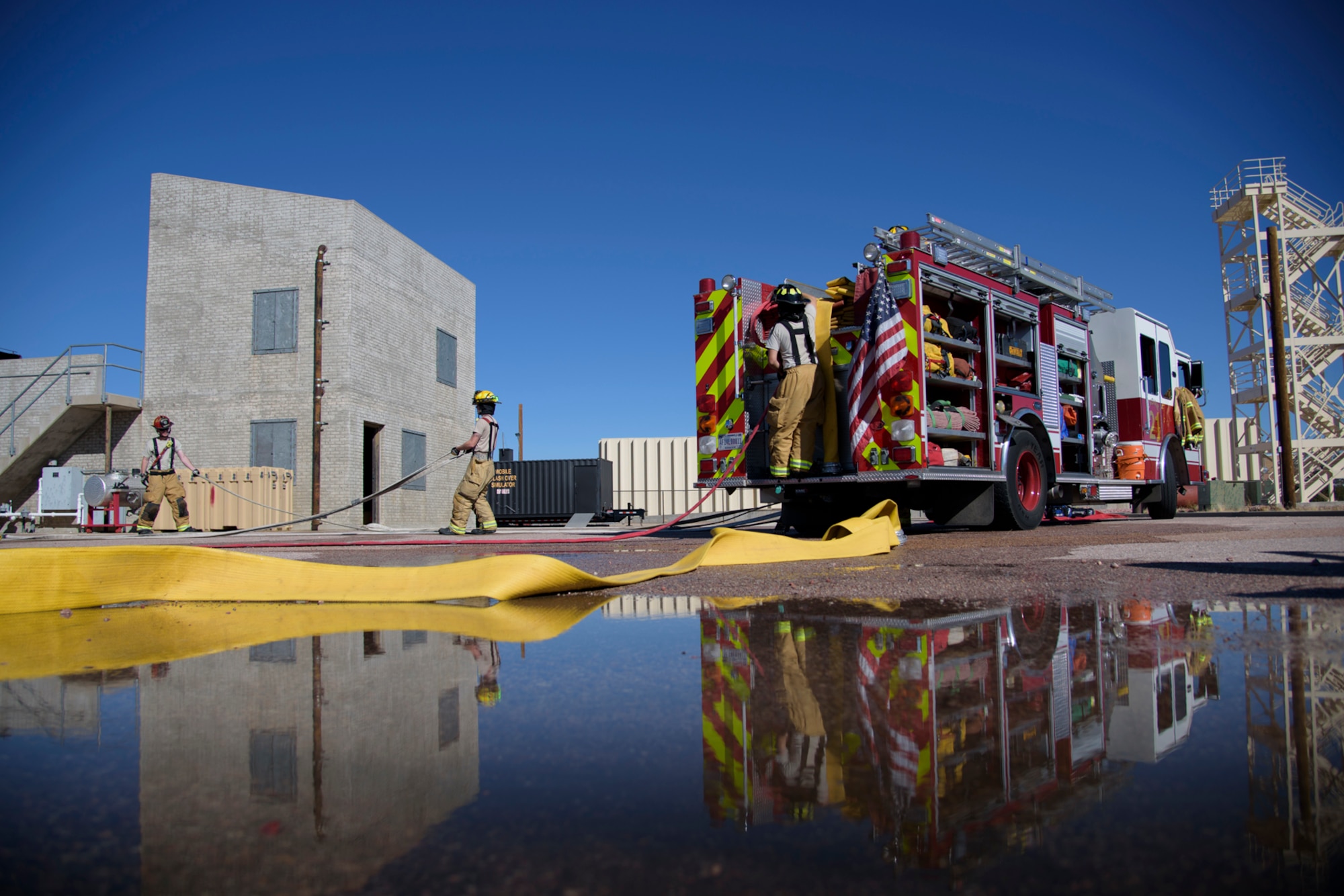PETERSON AIR FORCE BASE, Colo. – Firemen assigned to the Peterson Air Force Base Fire Department roll the hoses used at a simulated structure fire during Condor Crest at Peterson AFB, Colo., Nov. 3, 2016.  Condor Crest is a wing-wide exercise used to evaluate crisis response and unit effectiveness. (U.S. Air Force photo by Airman 1st Class Dennis Hoffman)