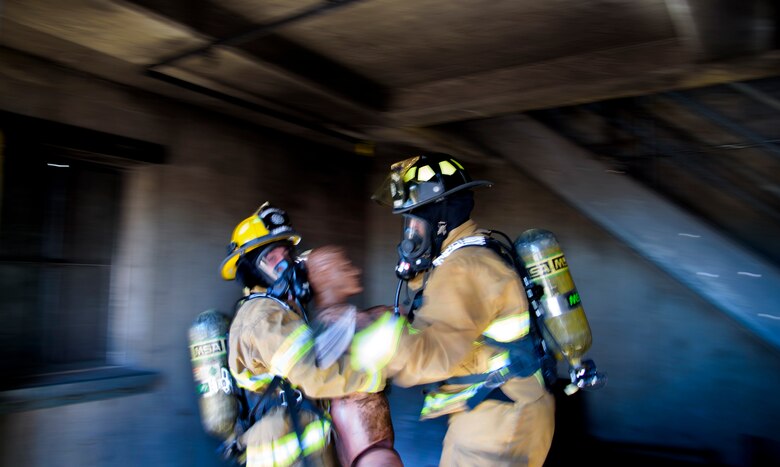 PETERSON AIR FORCE BASE, Colo. – Firemen assigned to the Peterson Air Force Base Fire Department carry a dummy out of a simulated structure fire during Condor Crest at Peterson AFB, Colo., Nov. 3, 2016.  Condor Crest is a wing-wide exercise used to evaluate crisis response and unit effectiveness. (U.S. Air Force photo by Airman 1st Class Dennis Hoffman)
