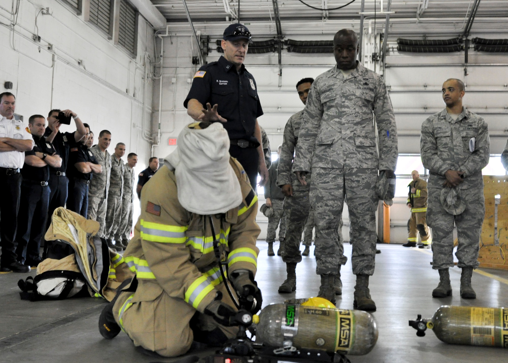 Kristofer Maynard, 92nd Civil Engineer Squadron firefighter, explains to Brig. Gen. Stacey Hawkins, Air Mobility Command director of logistics, engineering and force protection, some of the training firefighters go through during a base tour Nov. 7, 2016, at Fairchild Air Force Base, Wash. One aspect of firefighter training is putting an oxygen tank together and equipping it while blindfolded. (U.S. Air Force photo/Airman 1st Class Taylor Shelton)
