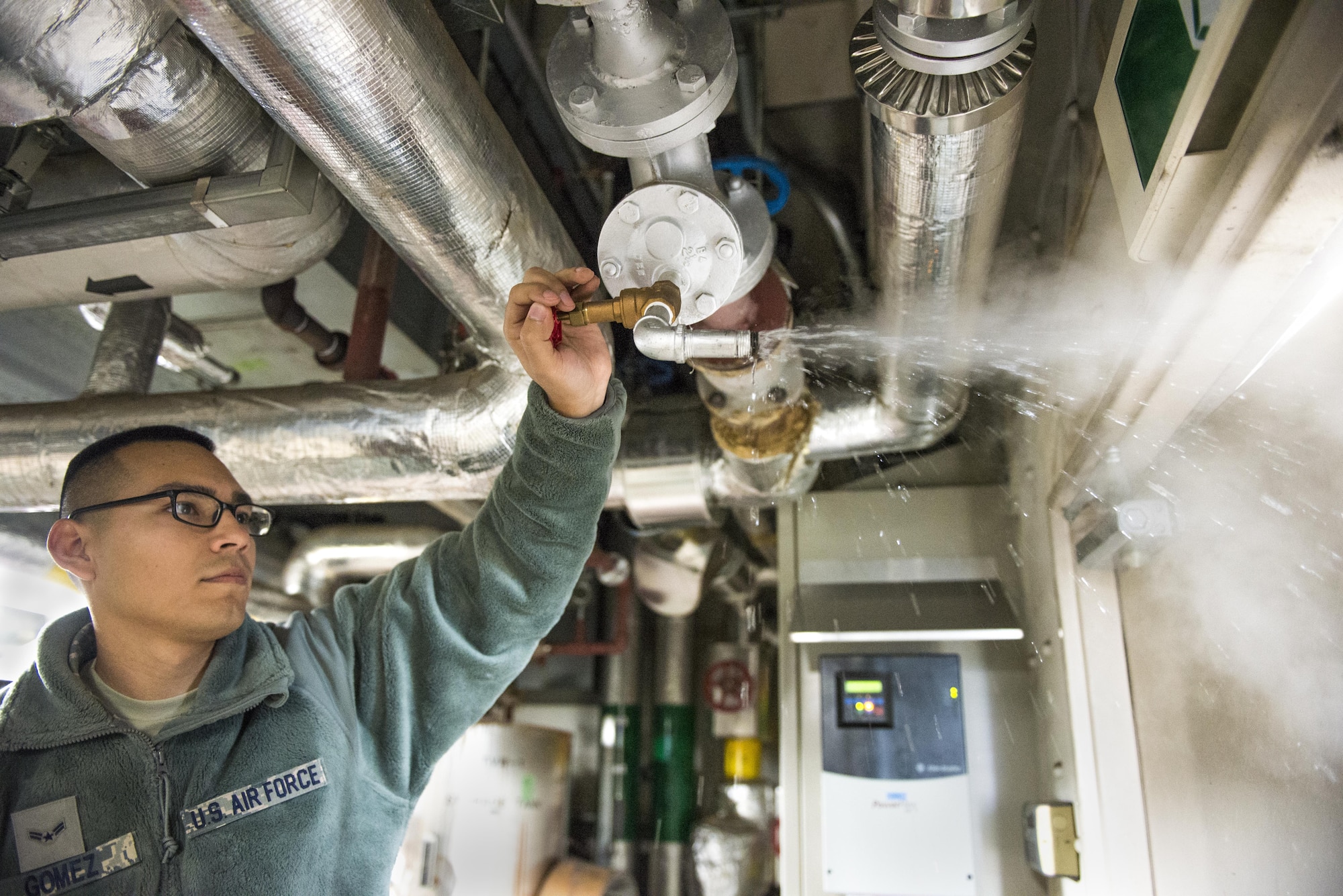 Airman 1st Class Michael Gomez, 374th Civil Engineer Squadron heating, ventilation and air conditioning technician, bleads out air from main steam line running into a building on Nov. 8, 2016, at Yokota Air Base, Japan. Each year the 374th CES goes through the process of switching the bases HVAC systems from cool to hot air for the upcoming winter season. (U.S. Air Force photo by Airman 1st Class Donald Hudson/Released)