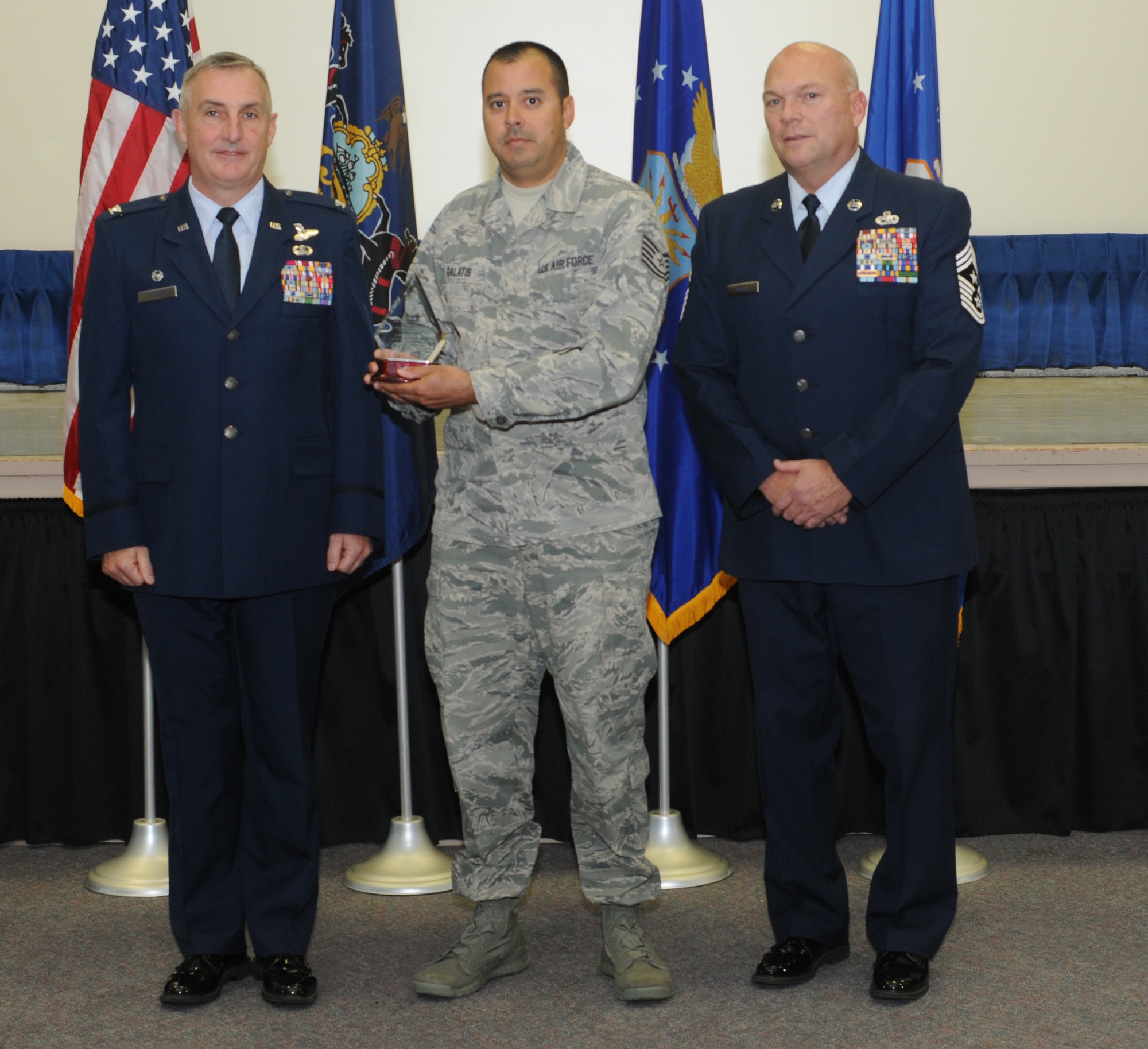 Technical Sgt. Alexis Galatis, a 111th Attack Wing production recruiter, stands with 111th ATKW Commander Col. Howard Eissler and Wing Command Chief Master Sgt. Paul Frisco while receiving the Fiscal Year 2015 State Award at Horsham Air Guard Station. Pa., on November 6, 2016. Galatis received the State Annual Production award in recognition of leading the state in most accessions having totaled 58. The award symbolizes a commitment to the making sure the Air National Guard obtains and retains quality members who will be an asset to the mission. (U.S. National Guard photo by Senior Airman Timi Jones)
