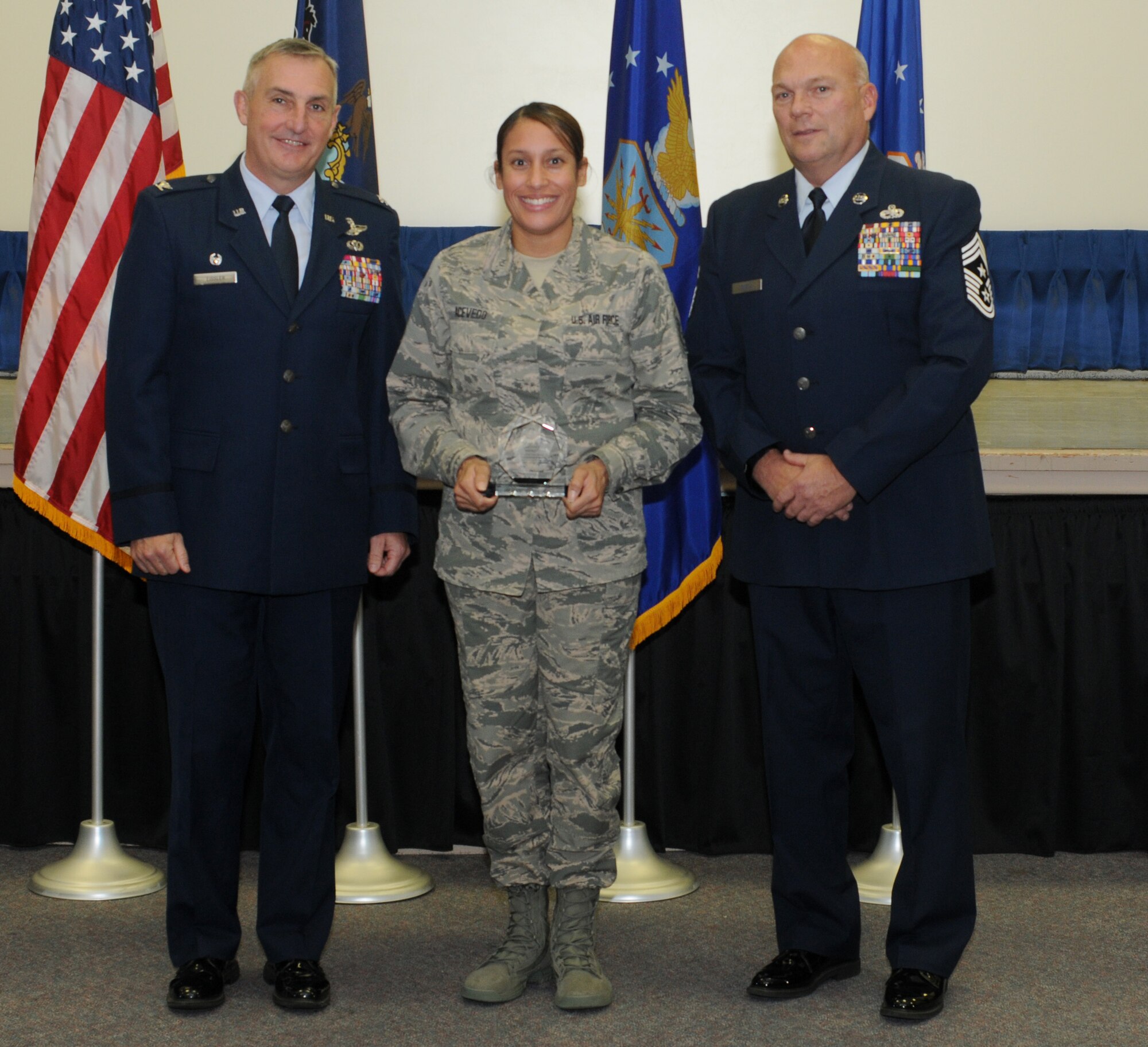 Master Sgt. Talitacumi Acevedo, the 111th Attack Wing recruiting and retention manager, stands with 111th ATKW Commander Col. Howard Eissler and Wing Command Chief Master Sgt. Paul Frisco while receiving the Fiscal Year 2015 State Award at Horsham Air Guard Station, Pa., on November 6, 2016. Acevedo received the State Recruiting and Retention Manager (RRM) of the Year award for being the top RRM in the state with superior retention programs and 20 total accessions. The award symbolizes a commitment to the making sure the Air National Guard obtains and retains quality members who will be an asset to the mission. (U.S. National Guard photo by Senior Airman Timi Jones)