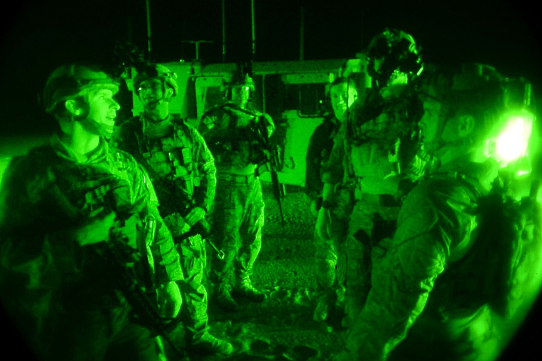 As seen through a night-vision device, airmen discuss a mission before participating in raid scenario during Southern Strike 17 at Camp Shelby Joint Forces Training Center, Miss., Oct. 31, 2016. The airmen are terminal attack and tactical air controllers. Air Force photo by Senior Airman Clayton Cupit