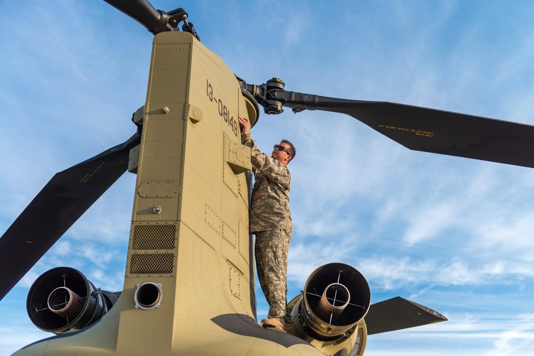 An Army crew chief checks the rear rotator blades on a CH-47 Chinook helicopter before a slingload operation at Hunter Army Airfield, Ga., Nov. 6, 2016. Army photo by Lt. Col. Brian J. Fickel