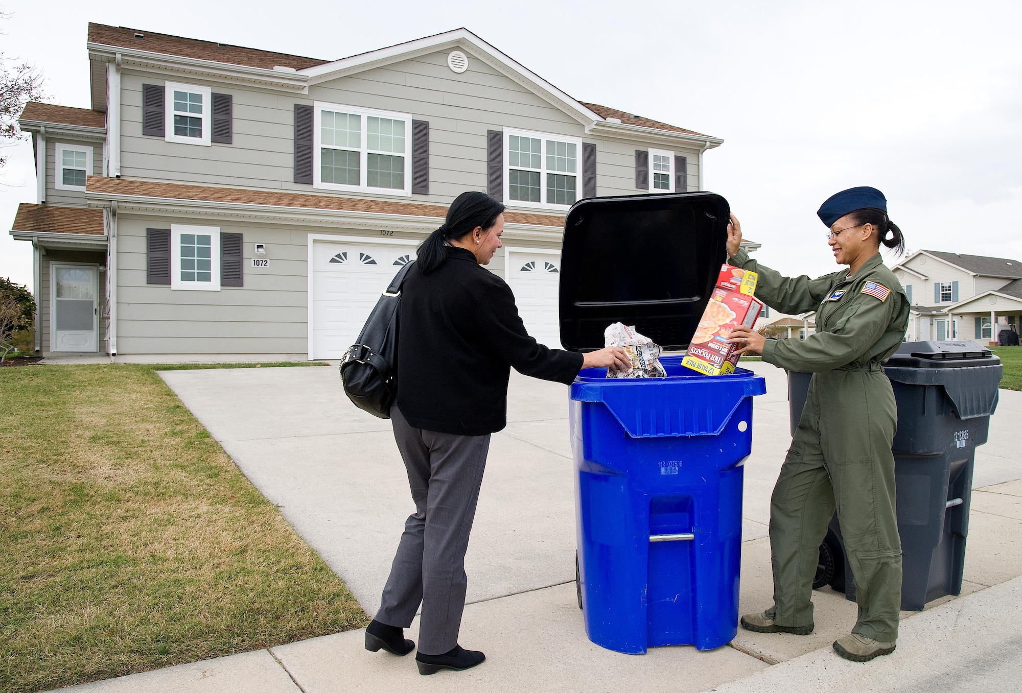 Sophia Reeves, Hunt Companies, Inc., Eagle Heights at Dover community director and Staff Sgt. Rachel Patterson, 3d Airlift Squadron loadmaster, place items in a 96-gallon recycle container Nov. 3, 2016, in Eagle Heights housing area on Dover Air Force Base, Del. In addition to curb-side recyclable pick up, two roll-off bins located at the Housing Maintenance office, building 3720 on Pine Cabin Road are available to Eagle Heights residents for bulk items such as furniture and a bin for metal items. (U.S. Air Force photo by Roland Balik)