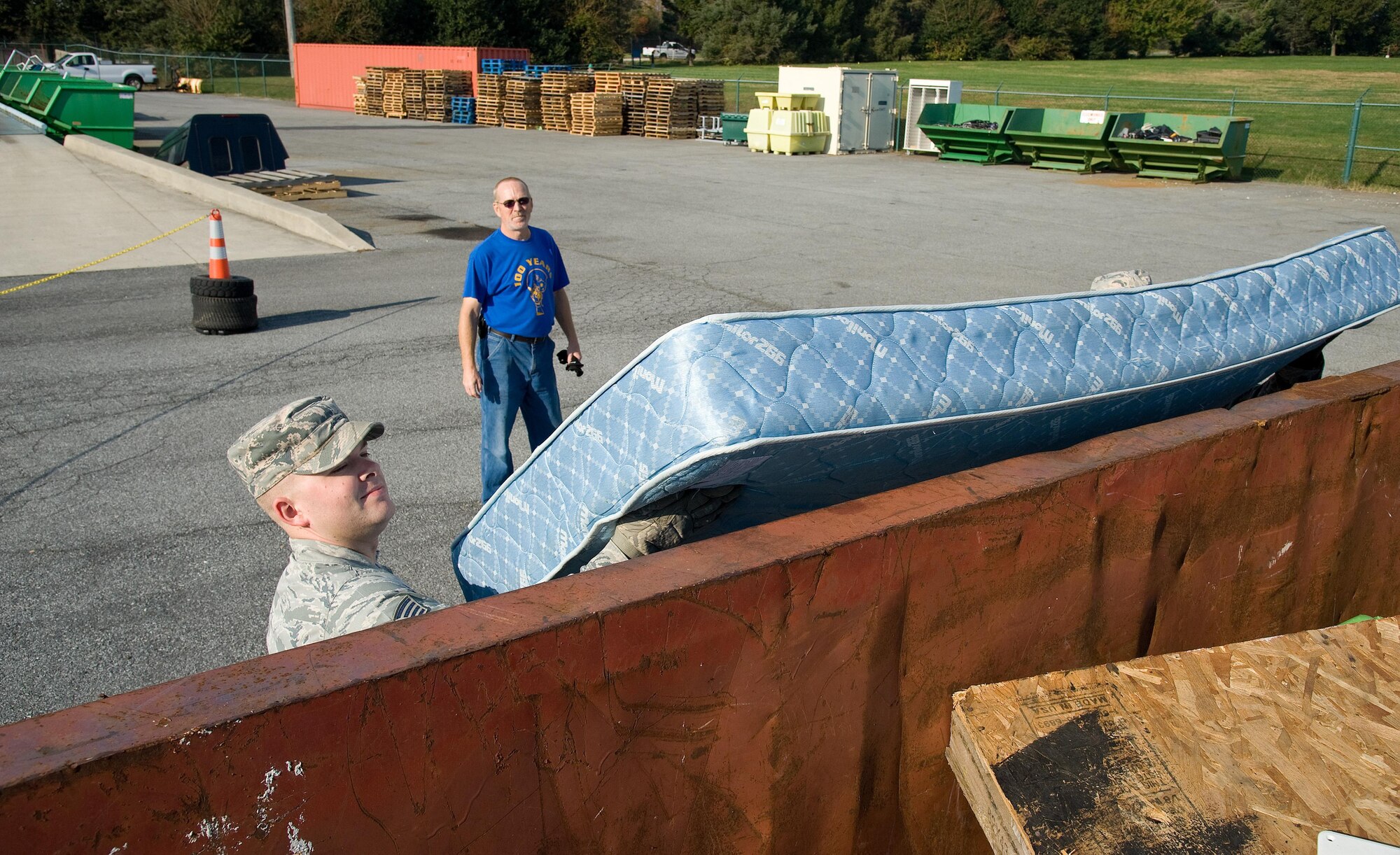 Deral Freysinger, 436th Civil Engineer Squadron qualified recycling program manager, watches Staff Sgt. Jonathan Judy, 436th CES airmen dormitory leader, place a mattress in a 30-cubic yard roll-off container Nov. 3, 2016, at the Recycling Center on Dover Air Force Base, Del. Freysinger ensured all items brought to the Recycling Center was placed in the proper containers. (U.S. Air Force photo by Roland Balik)