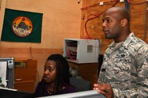 Staff Sgt. Kerry Lewis, a 386th Expeditionary Communications Squadron client systems supervisor,  talks with a customer at an undisclosed location in Southwest Asia Nov. 8, 2016. Lewis is deployed from the 2nd Communications Squadron at Barksdale Air Force Base, La. (U.S. Air Force photo by Senior Airman Andrew Park/Released)