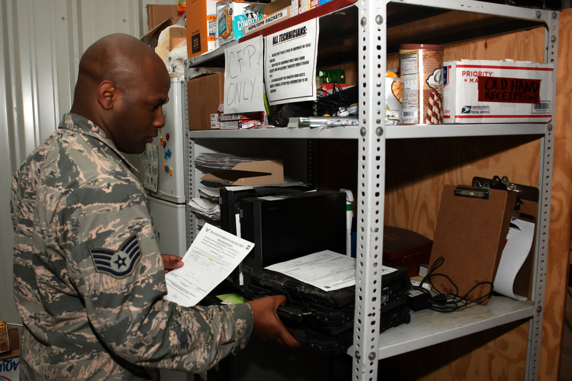 Staff Sgt. Kerry Lewis, a 386th Expeditionary Communications Squadron client systems supervisor,  retrieves a laptop for a customer at an undisclosed location in Southwest Asia Nov. 8, 2016. Lewis is deployed from the 2nd Communications Squadron at Barksdale Air Force Base, La. (U.S. Air Force photo by Senior Airman Andrew Park/Released)