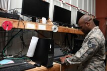Staff Sgt. Kerry Lewis, a 386th Expeditionary Communications Squadron client systems supervisor,  examines a laptop for a customer at an undisclosed location in Southwest Asia Nov. 8, 2016. Lewis is deployed from the 2nd Communications Squadron at Barksdale Air Force Base, La. (U.S. Air Force photo by Senior Airman Andrew Park/Released)