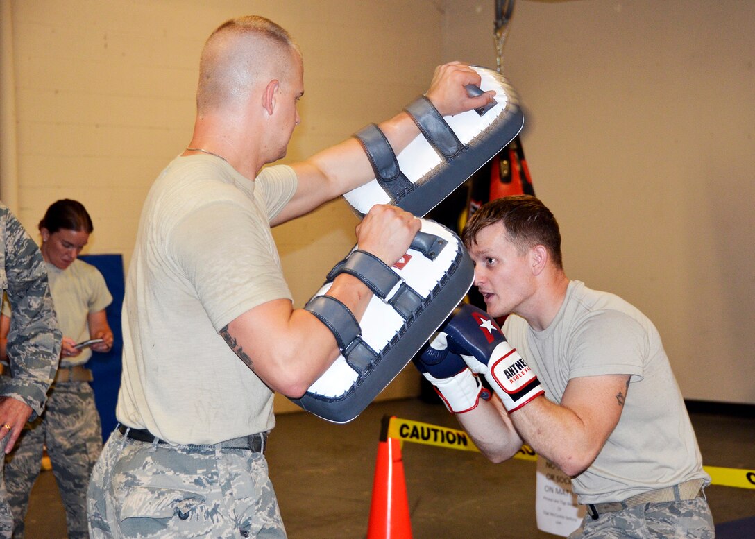 445th Security Forces Squadron Airmen Tech. Sgt. Chris Booth, left, and Staff Sgt. Jake McCorkle practice their combatives skills using squadron equipment in the newly-renovated bay exercise area. The two Citizen Airmen host monthly martial arts workouts on the evening before UTA begins. (U.S. Air Force photo/Staff Sgt. Rachel Ingram)