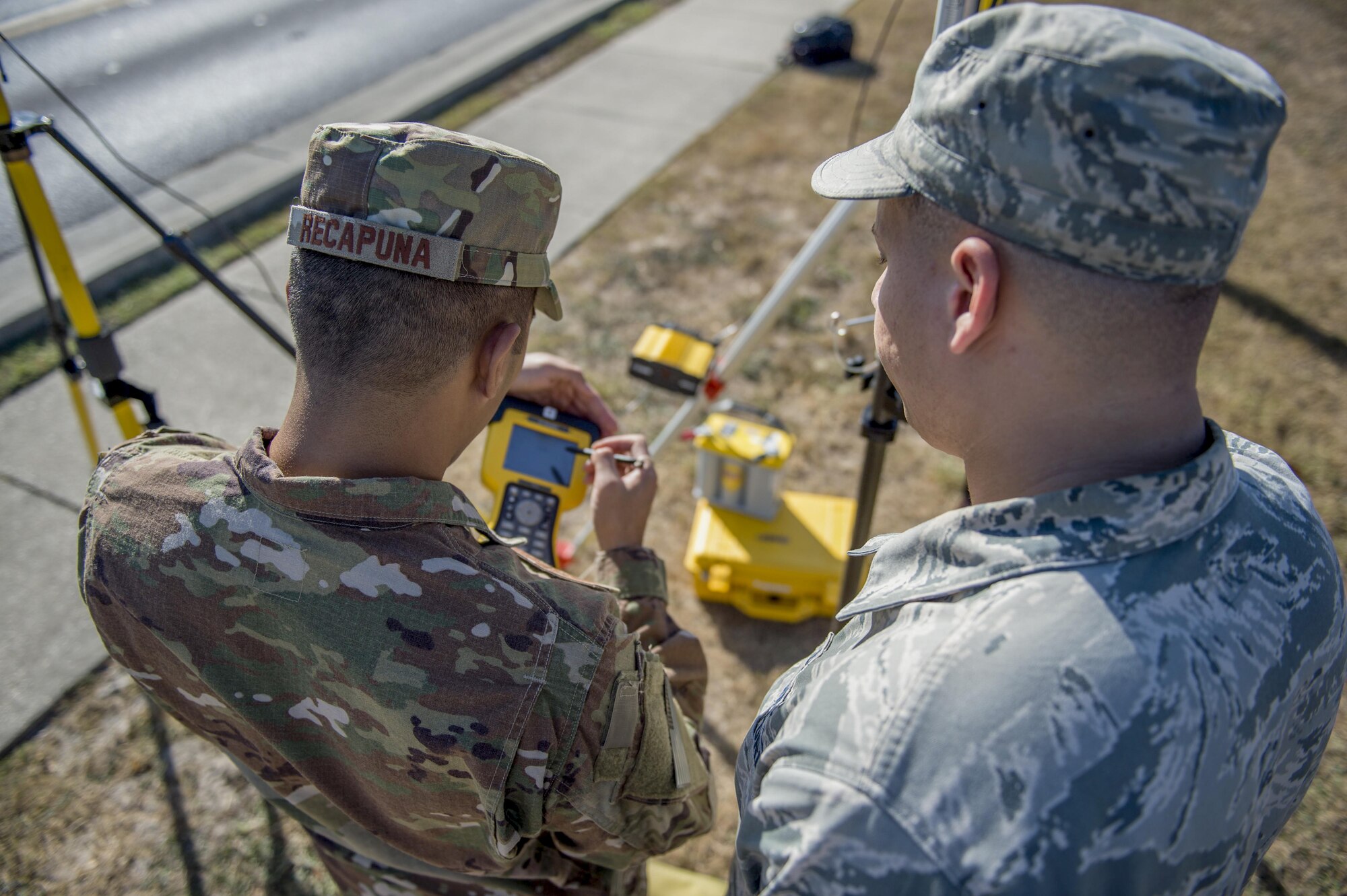 Senior Airmen Giann Recapunra and Adam Gleason, engineering specialists with the 1st Special Operations Civil Engineer Squadron, confirm the location of a facility at Hurlburt Field, Fla., Nov. 7, 2016. The Global Positioning System corrects itself for an accurate location read using real-time kinematics. (U.S. Air Force photo by Airman 1st Class Isaac O. Guest IV)