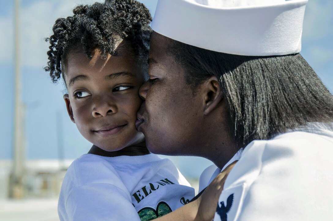 Navy Petty Officer 1st Class Ashley Johnson kisses her daughter at Naval Base Guam in Santa Rita, Guam, Nov. 8, 2016, after completing a five-month deployment. Johnson is assigned to assigned to the submarine tender USS Frank Cable. The ship operated throughout the Indo-Asia-Pacific region to provide flexibility to the fleet commanders, extending the range and impact of U.S. naval forces in the U.S. 5th and 7th fleets. Navy photo by Seaman Alana Langdon
