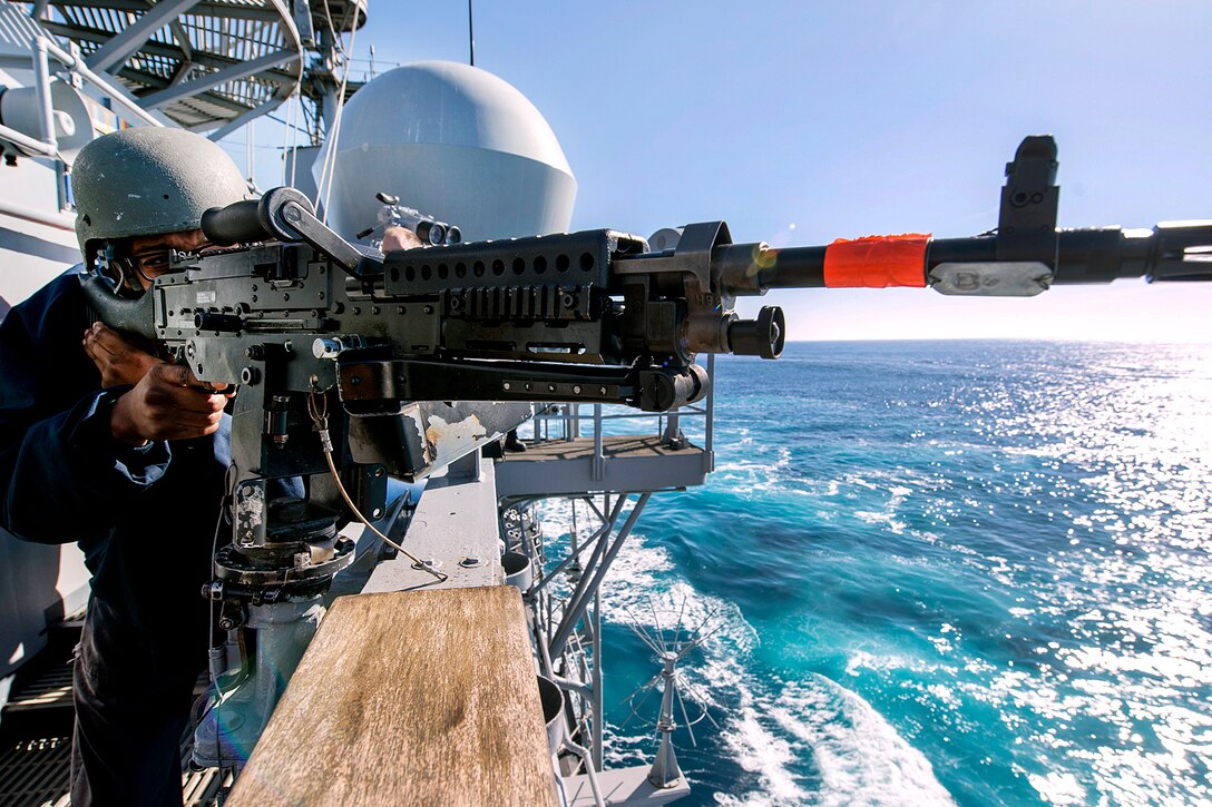 Navy Petty Officer 2nd Class Ryan Nicholas mans an M240B machine gun on the port bridge wing of the Ticonderoga-class guided-missile cruiser USS Lake Champlain as part of the small craft action team during a show of force transit training exercise in the Pacific Ocean, Nov. 4, 2016. Navy photo by Petty Officer 2nd Class Nathan K. Serpico
