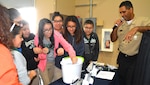 Harlem, N.Y. native, Petty Officer 1st Class Daniel Jimenez, a recruiter assigned to Navy Recruiting Station Ingram, Navy Recruiting District San Antonio, instructs middle school girls on the Penny Boat Challenge during the Hispanic Chamber of Commerce's CORE4 STEM Expo held at the Freeman Expo Hall.  Jimenez is a 1999 graduate of A. Philip Randolph High School in New York.  The expo, consisting an all-female day and all-male day, featured leaders from the energy, science, computer, and aerospace industries and presented students with the opportunity to meet with high-profile representatives from Fortune 500 companies and governmental agencies.  Students experienced hands-on and demonstration projects, listened to speakers from exciting Science, Technology, Engineering, and Mathematics (STEM) fields, and spoke with Navy recruiters to discuss degree plans in interested fields and financial aid options. (Navy Photo by Burrell D. Parmer, Navy Recruiting District San Antonio Public Affairs/Released)