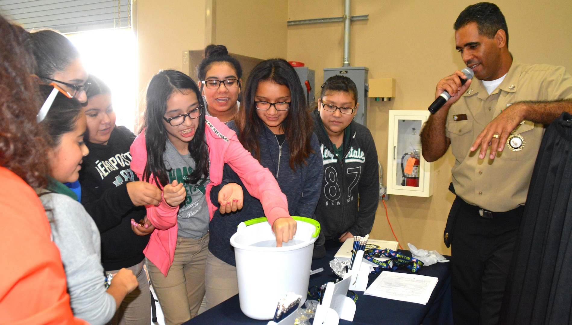 Harlem, N.Y. native, Petty Officer 1st Class Daniel Jimenez, a recruiter assigned to Navy Recruiting Station Ingram, Navy Recruiting District San Antonio, instructs middle school girls on the Penny Boat Challenge during the Hispanic Chamber of Commerce's CORE4 STEM Expo held at the Freeman Expo Hall.  Jimenez is a 1999 graduate of A. Philip Randolph High School in New York.  The expo, consisting an all-female day and all-male day, featured leaders from the energy, science, computer, and aerospace industries and presented students with the opportunity to meet with high-profile representatives from Fortune 500 companies and governmental agencies.  Students experienced hands-on and demonstration projects, listened to speakers from exciting Science, Technology, Engineering, and Mathematics (STEM) fields, and spoke with Navy recruiters to discuss degree plans in interested fields and financial aid options. (Navy Photo by Burrell D. Parmer, Navy Recruiting District San Antonio Public Affairs/Released)