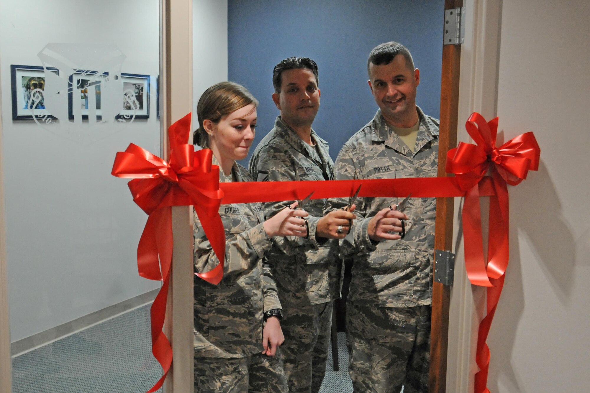Public Affairs Broadcast Journalist Airman 1st Class Sarah Gruber, Public Affairs Superintendent Master Sgt. Bob Barko Jr. and Command Chief Master Sgt. Robert Potts, all assigned to the 910th Airlift Wing, cut the ribbon for the new Airmen’s Suite during grand opening festivities for the space at the installation headquarters building here, Nov. 6, 2016. The new facility highlights the accomplishments of base units and serves a variety of purposes from meetings to promotion and awards boards. (U.S. Air Force photo/Tech. Sgt. James Brock)