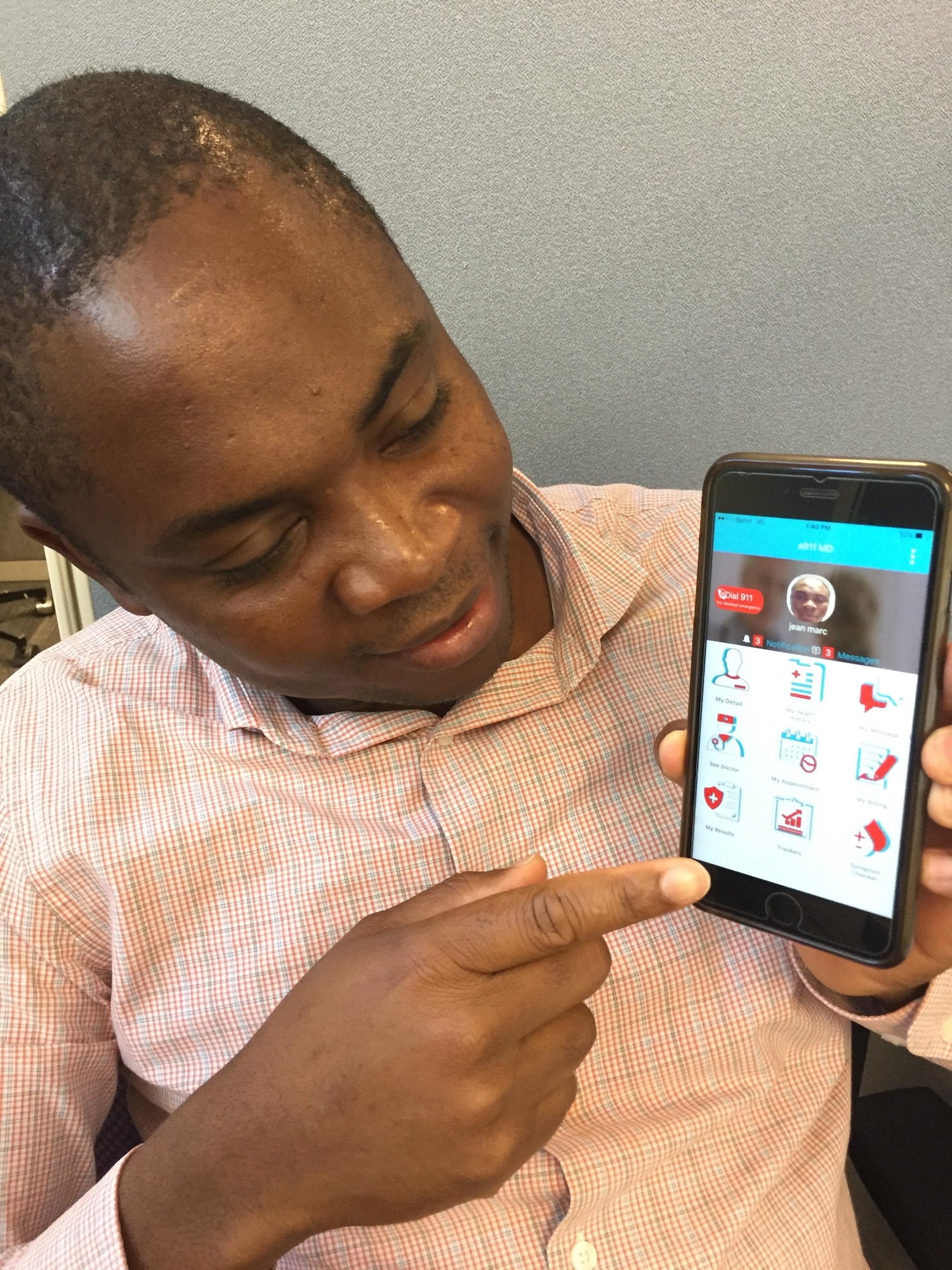 Senior Airman Jean Marc Tchazou, member of the 439th Force Support Squadron at Westover Air Reserve Base, Mass., shows members how to use e911md, a mobile application he created to help people connect with a doctor, but remain anonymous. (U.S. Air Force photo/ Capt. Meghan Smith)