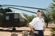 Retired Chief Master Sgt. Craig Bergman stands in front of the HH-3 