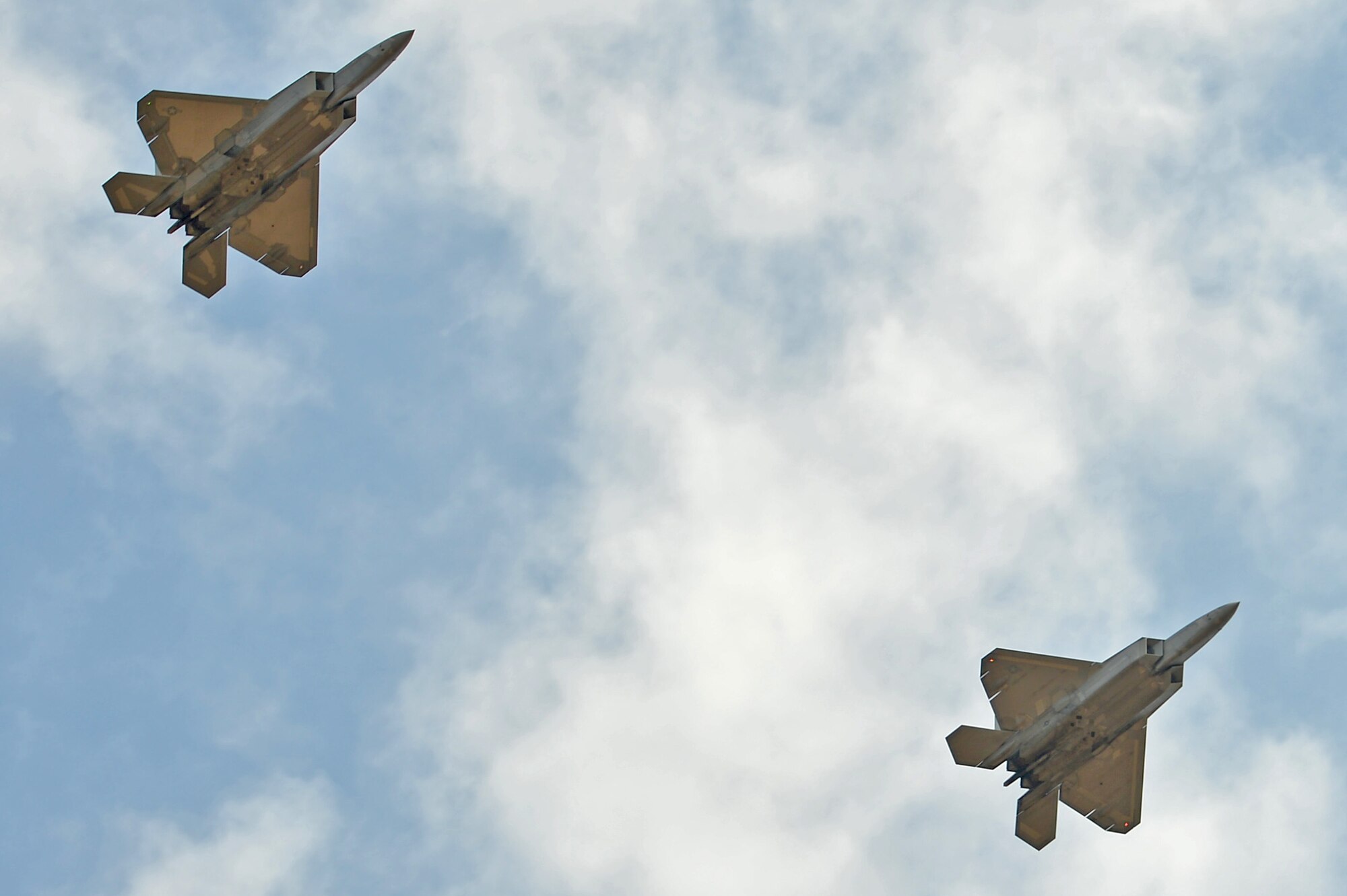 Two F-22 Raptors assigned to the 53rd Wing at Eglin Air Force Base, Fla., fly over onlookers below during an East Coast Airpower Demonstration at Poinsett Electronic Combat Range, Wedgefield, S.C., Oct. 27, 2016. The Raptor is capable of performing both air-to-air and air-to-ground operations, executing the Air Force mission worldwide. (U.S. Air Force photo by Airman 1st Class Christopher Maldonado) 
