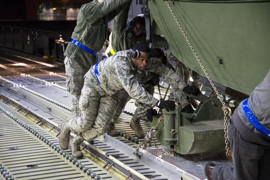Airman Jerry Booker, 60th Aerial Port Squadron, pushes a U.S. Army Bridge Erection Boat (BEB) onto a C-5M Super Galaxy May 7, 2016, at Travis Air Force Base, Calif. The 60th APS successfully uploaded multiple BEBs onto the aircraft where they were transported to Iraq in support of Operation Inherent Resolve. (U.S. Air Force by Staff Sgt. Charles Rivezzo)