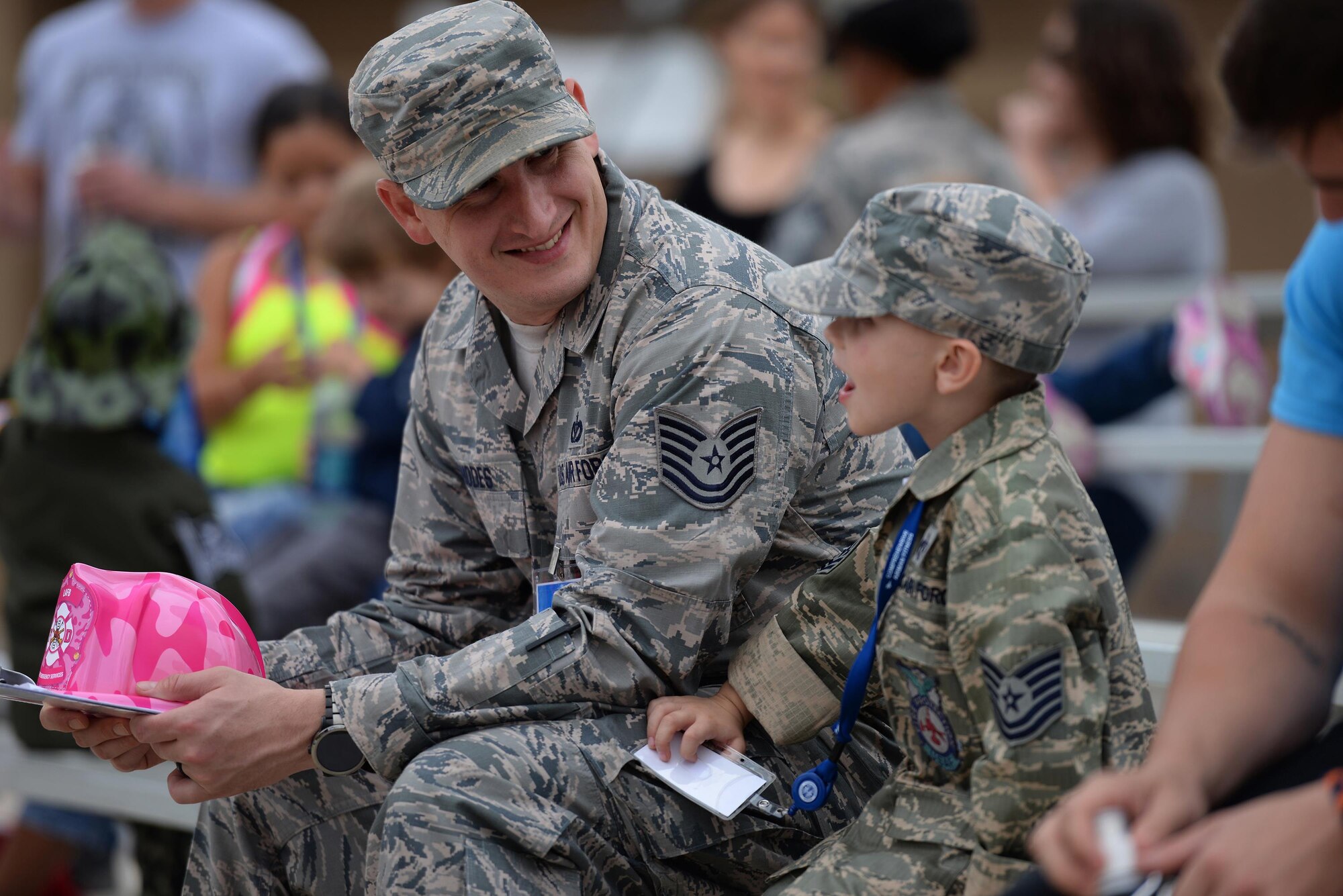 Tech. Sgt. Brian Rhodes, 47th Civil Engineer Squadron emergency response center NCO in charge, and his son wait for the military working dog demonstration during a junior deployment, on Laughlin Air Force Base, Texas, Nov. 5, 2016. The 47th Security Forces Squadron demonstrated their military working dog’s capabilities for a junior deployment held for base and local children. (U.S. Air Force photo/Airman 1st Class Benjamin N. Valmoja)