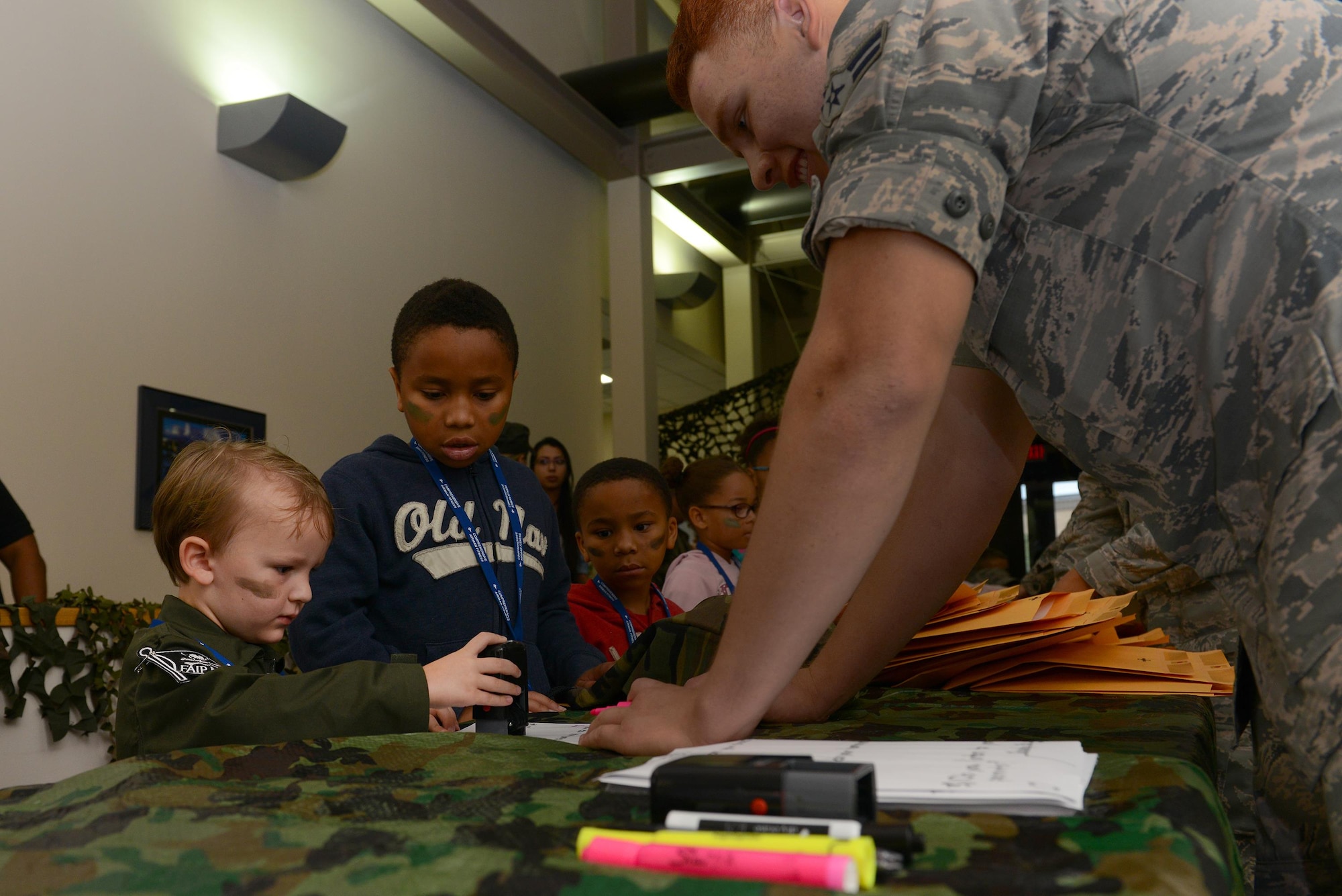 Airman 1st Class Leonardo Meza Camarena, 47th Comptroller Squadron financial technician, helps out-process one of Laughlin’s junior deployers, on Laughlin Air Force Base, Texas, Nov. 5, 2016. The Airman and Family Readiness Center held a mock deployment for base and local children to experience what a deployment could be like for military members. (U.S. Air Force photo/Airman 1st Class Benjamin N. Valmoja)