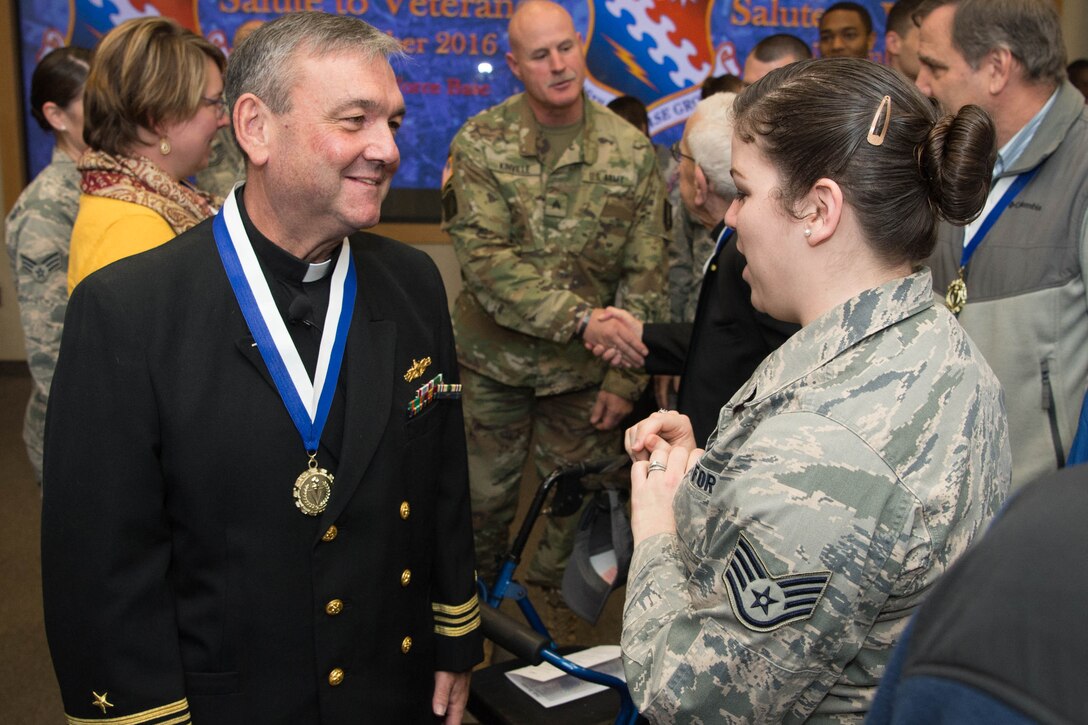 Retired Navy Lt. Cmdr. Richard Burton, now a Roman Catholic priest for the Archdiocese of Boston, meets Air Force Staff Sgt. Marjorie Brooks during the Salute to Veterans event at Hanscom Air Force Base, Mass., Nov. 9, 2016. Air Force photo by Jerry Saslav