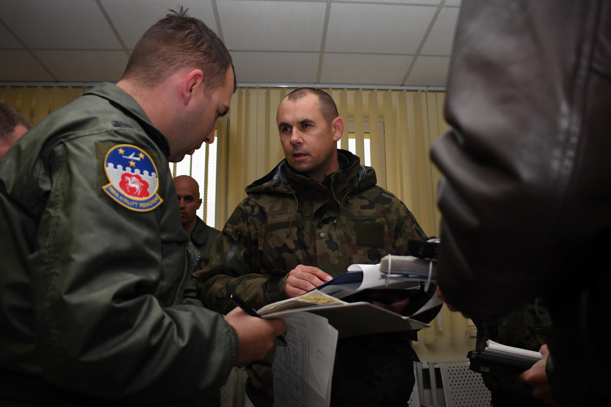 Capt. John Hill, 700th Airlift Squadron navigator, discusses a flight mission plan with a member of the Polish Air Force at Krakow Airport in Poland, Oct. 13, 2016. The 94th Airlift Wing, from Dobbins Air Reserve Base, Ga., and the 86th Airlift Wing, from Ramstein Air Base, Germany, trained jointly with the Polish air force during Aviation Detachment 17-1 in support of Operation Atlantic Resolve, Oct. 3-28. (U.S. Air Force photo by Staff Sgt. Alan Abernethy)