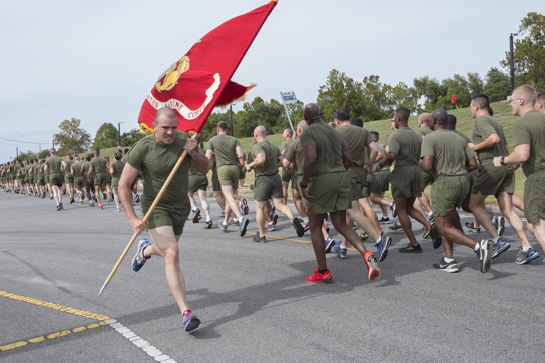 Lance Cpl. Benjamin T. Kulp, a fiscal clerk with Marine Forces Reserve, carries the Marine Corps Flag through the streets here during a 3-mile motivational formation run, Nov. 9, 2016. Each year, the Marines celebrate the Corps’ birthday with a cake-cutting ceremony followed by a run. Since Nov. 10, 1775, the United States Marine Corps has earned the reputation as the world's most effective expeditionary fighting force - engaging in combat on battlefields across the globe. (U.S. Marine Corps photo by Sgt. Sara Graham)