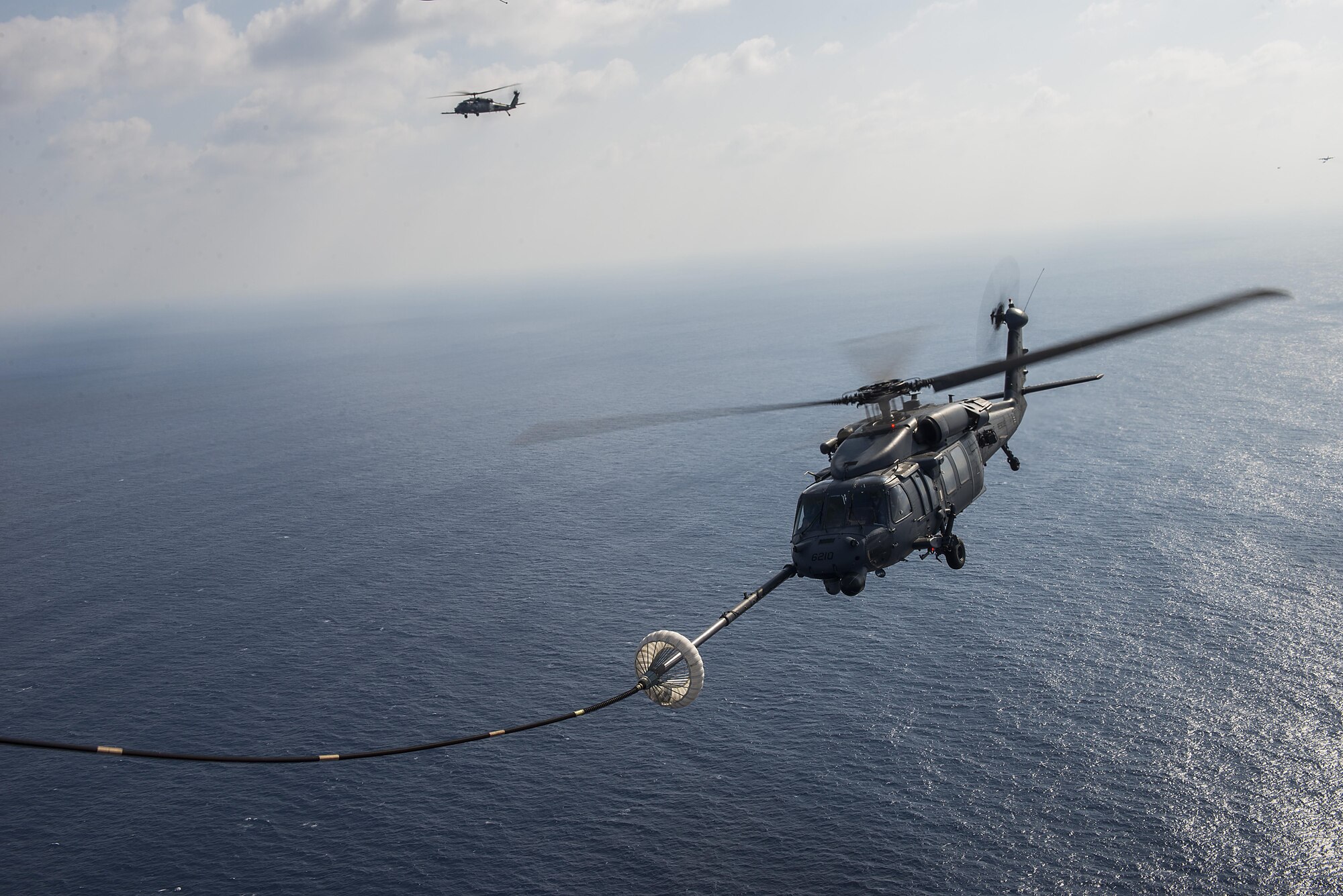 An HH-60 Pave Hawk from the 33rd Rescue Squadron refuels behind an MC-130J from the 17th Special Operations during exercise Keen Sword 17, Nov. 7, 2016, near Okinawa, Japan. The fundamental role of U.S. forces in Japan is to deter aggression and maintain peace and security in the region, and is an essential component of the U.S.-Japan alliance. (U.S. Air Force photo by Senior Airman Stephen G. Eigel/released)