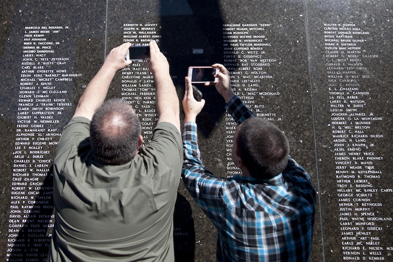 Family members take photos of their loved one’s name inscribed on the City of Henderson, Nev. Veterans Memorial Wall during a Veterans Day celebration, Nov. 5.  Names are etched onto the black marble wall to memorialize Henderson residence who served to keep our nation free. (U.S. Air Force photo by Lawrence Crespo)