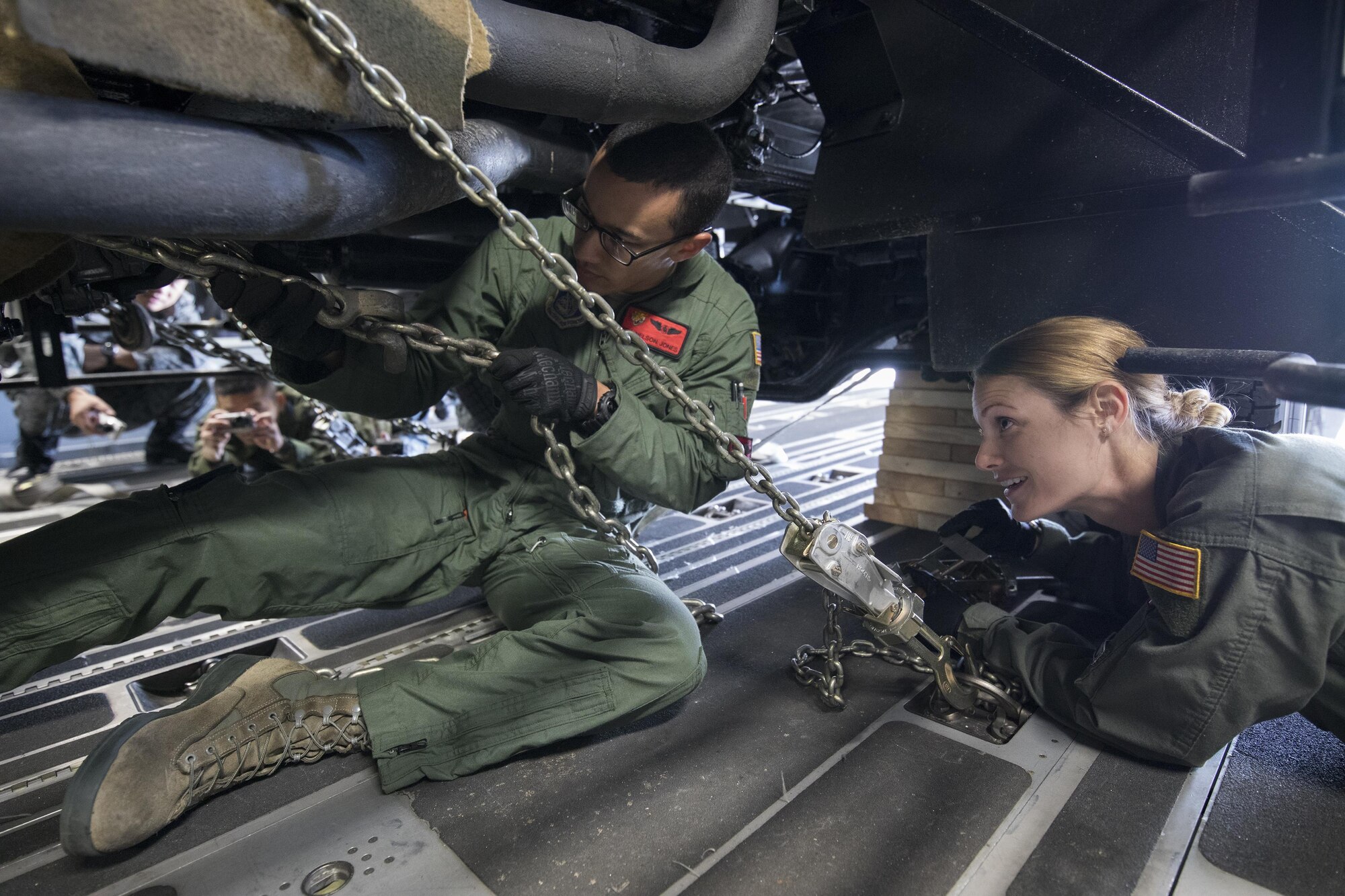 (Left to right) U.S. Air Force Senior Airman Nelson Jones and Airman 1st Class Lauren Sheppard, both with the 535th Airlift Squadron C-17 loadmasters, secure a tie-down chain on a Japan Air Self-Defense Force Electric Power Plant vehicle Nov. 6, 2016 at Yokota Air Base, Japan, during the exercise Keen Sword 2017. This is the first time the vehicle loading onto a C-17. Units from the U.S. military conduct training with Japan Self-Defense Forces counterparts at military installations throughout Japan, the Mariana Islands and in the surrounding waters. All participating units train in a comprehensive scenario that is designed to practice the critical capabilities and interoperability required to support the defense of Japan, and to respond to a potential crisis or contingency in the Indo-Asia-Pacific region. (U.S. Air Force photo by Yasuo Osakabe/Released)