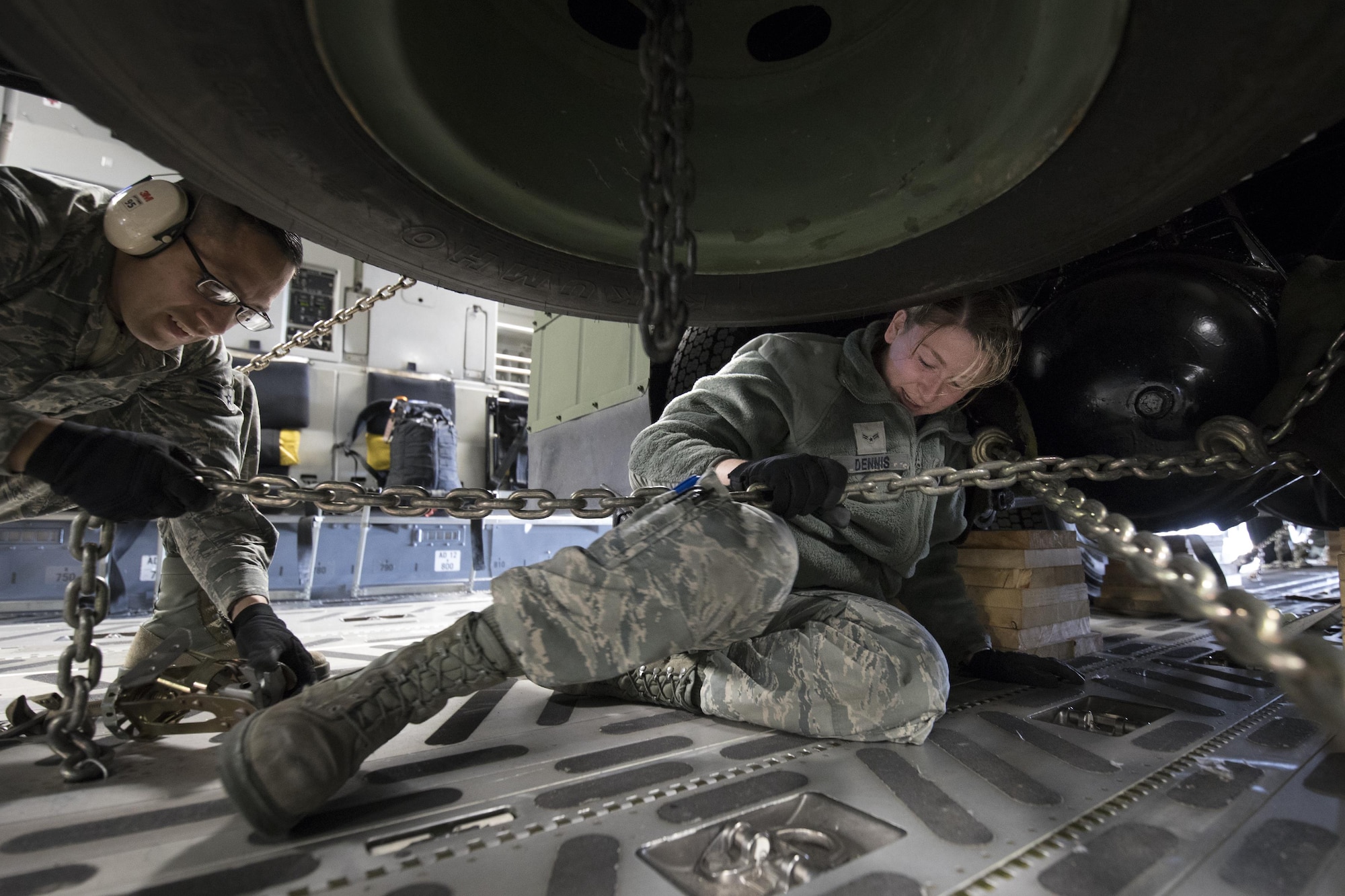 (Right to left) U.S. Air Force Airman 1st Class Ashley Dennis and A1c Galdamez Moran, both with the 730th Air Mobility Squadron air freight technicians, secure a tie-down chain on a Japan Air Self-Defense Force Electric Power Plant vehicle Nov. 6, 2016 at Yokota Air Base, Japan, during the exercise Keen Sword 2017. This is the first time the vehicle loading onto a C-17. Units from the U.S. military conduct training with Japan Self-Defense Forces counterparts at military installations throughout Japan, the Mariana Islands and in the surrounding waters. All participating units train in a comprehensive scenario that is designed to practice the critical capabilities and interoperability required to support the defense of Japan, and to respond to a potential crisis or contingency in the Indo-Asia-Pacific region. (U.S. Air Force photo by Yasuo Osakabe/Released) 