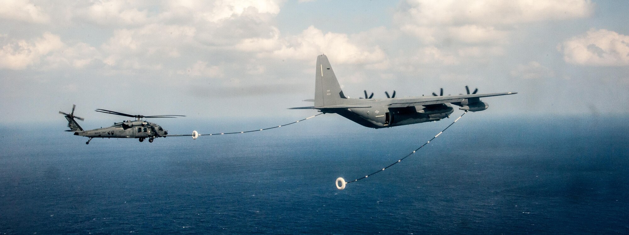 A U.S. Air Force HH-60G Pave Hawk helicopter assigned to the 33rd Rescue Squadron performs in-flight refueling with a MC-130J Commando II from the 17th Special Operations Squadron during a training exercise Nov. 4, 2016, off the coast of Okinawa, Japan. The 33rd RS performs military personnel recovery, civil search and rescue, medical evacuation, disaster response, and humanitarian assistance. (U.S. Air Force photo by Senior Airman John Linzmeier)