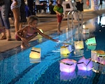 SINGAPORE (Nov. 7, 2016) – Aria Terry, sets a glow lantern afloat at Navy Region Singapore’s Terror Club during an event to raise awareness about domestic violence and sexual assault, Nov. 4, 2016. The lanterns symbolize giving hope and empowerment to those victims of sexual assault and domestic violence around the world. Military service members and their families along with DoD civilians assigned to Navy Region Singapore walked along the streets of Sembawang, Singapore to raise awareness and support for victims of sexual assault and domestic violence. The event entitled, Take Back the Night, included more than 30 participants who gathered to peacefully march along the streets of Singapore and take back the fear that is surrounded by the belief that violence is perpetrated by strangers in the night. (Official U.S. Navy photo by Marc Ayalin)