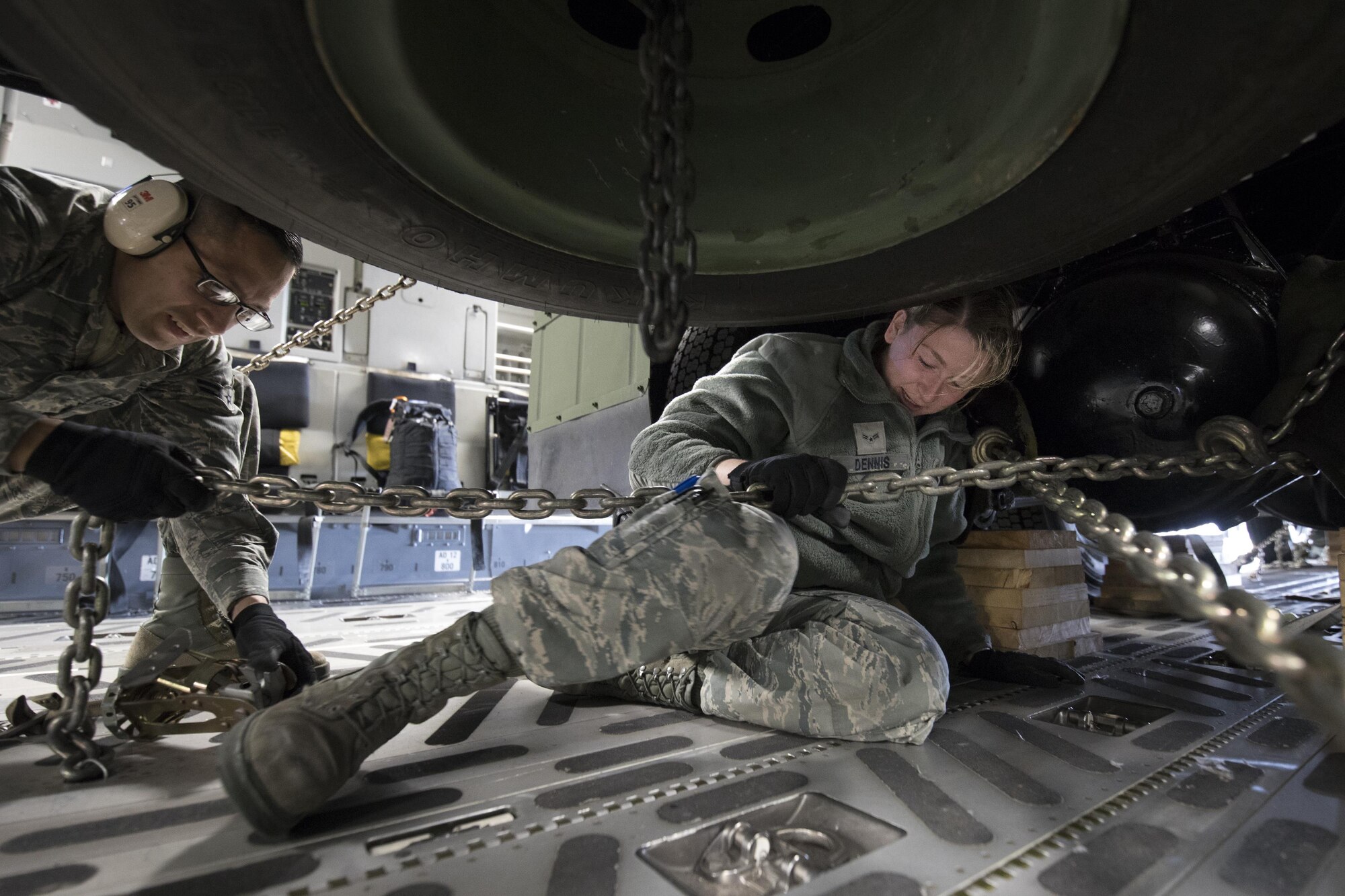 (Right to left) U.S. Air Force Airman 1st Class Ashley Dennis and A1c Galdamez Moran, both with the 730th Air Mobility Squadron air freight technicians, secure a tie-down chain on a Japan Air Self-Defense Force Electric Power Plant vehicle Nov. 6, 2016 at Yokota Air Base, Japan, during the exercise Keen Sword 2017. This is the first time the vehicle loading onto a C-17. Units from the U.S. military conduct training with Japan Self-Defense Forces counterparts at military installations throughout Japan, the Mariana Islands and in the surrounding waters. All participating units train in a comprehensive scenario that is designed to practice the critical capabilities and interoperability required to support the defense of Japan, and to respond to a potential crisis or contingency in the Indo-Asia-Pacific region. (U.S. Air Force photo by Yasuo Osakabe/Released) 