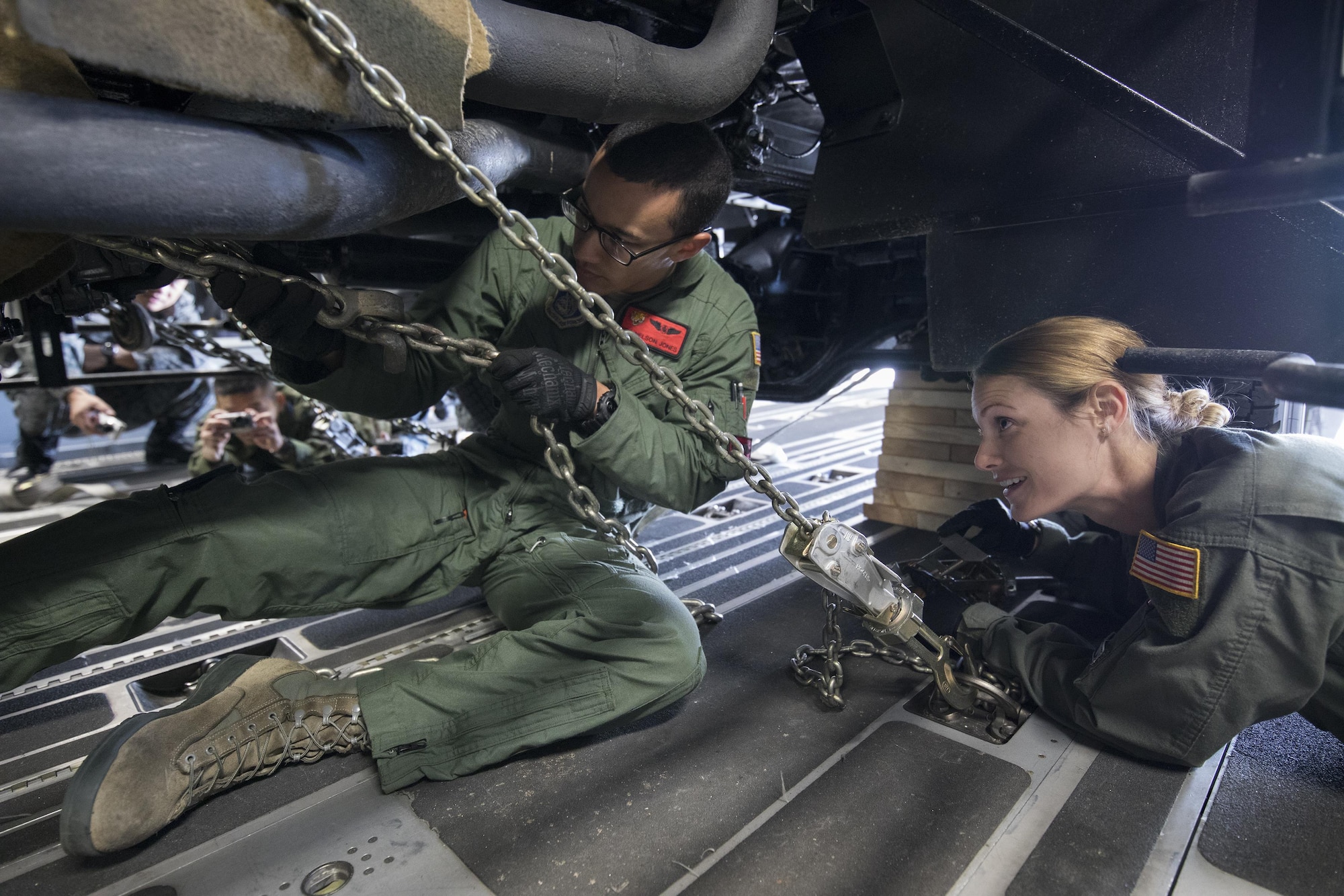 (Left to right) U.S. Air Force Senior Airman Nelson Jones and Airman 1st Class Lauren Sheppard, both with the 535th Airlift Squadron C-17 loadmasters, secure a tie-down chain on a Japan Air Self-Defense Force Electric Power Plant vehicle Nov. 6, 2016 at Yokota Air Base, Japan, during the exercise Keen Sword 2017. This is the first time the vehicle loading onto a C-17. Units from the U.S. military conduct training with Japan Self-Defense Forces counterparts at military installations throughout Japan, the Mariana Islands and in the surrounding waters. All participating units train in a comprehensive scenario that is designed to practice the critical capabilities and interoperability required to support the defense of Japan, and to respond to a potential crisis or contingency in the Indo-Asia-Pacific region. (U.S. Air Force photo by Yasuo Osakabe/Released)