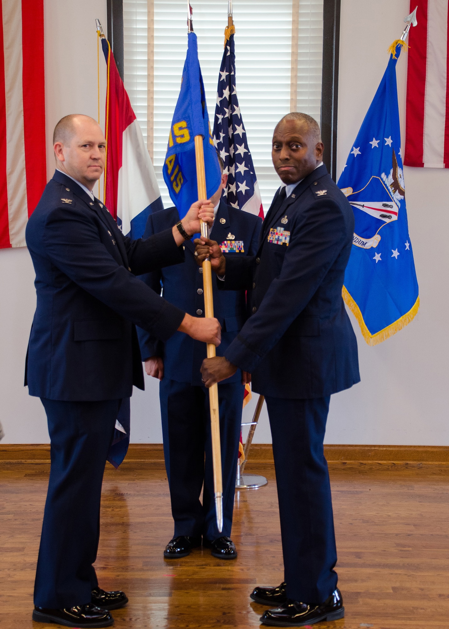 Col. William Boothman, 157th Air Operations Group commander, hands the unit guidon, and with it, leadership authority, to Col. Chip Atterbury, 157th Air Intelligence Squadron commander, at Jefferson Barracks Air National Guard Base, Missouri, during drill Nov. 5, 2016. Three new commanders took charge of three new squadrons -- the 157th AIS, the 157th Combat Operations Squadron and the 157th Air Communications Squadron, new units of the 157th AOG -- at a single assumption of command ceremony. (U.S. Air National Guard photo by Staff Sgt. Brittany Cannon)