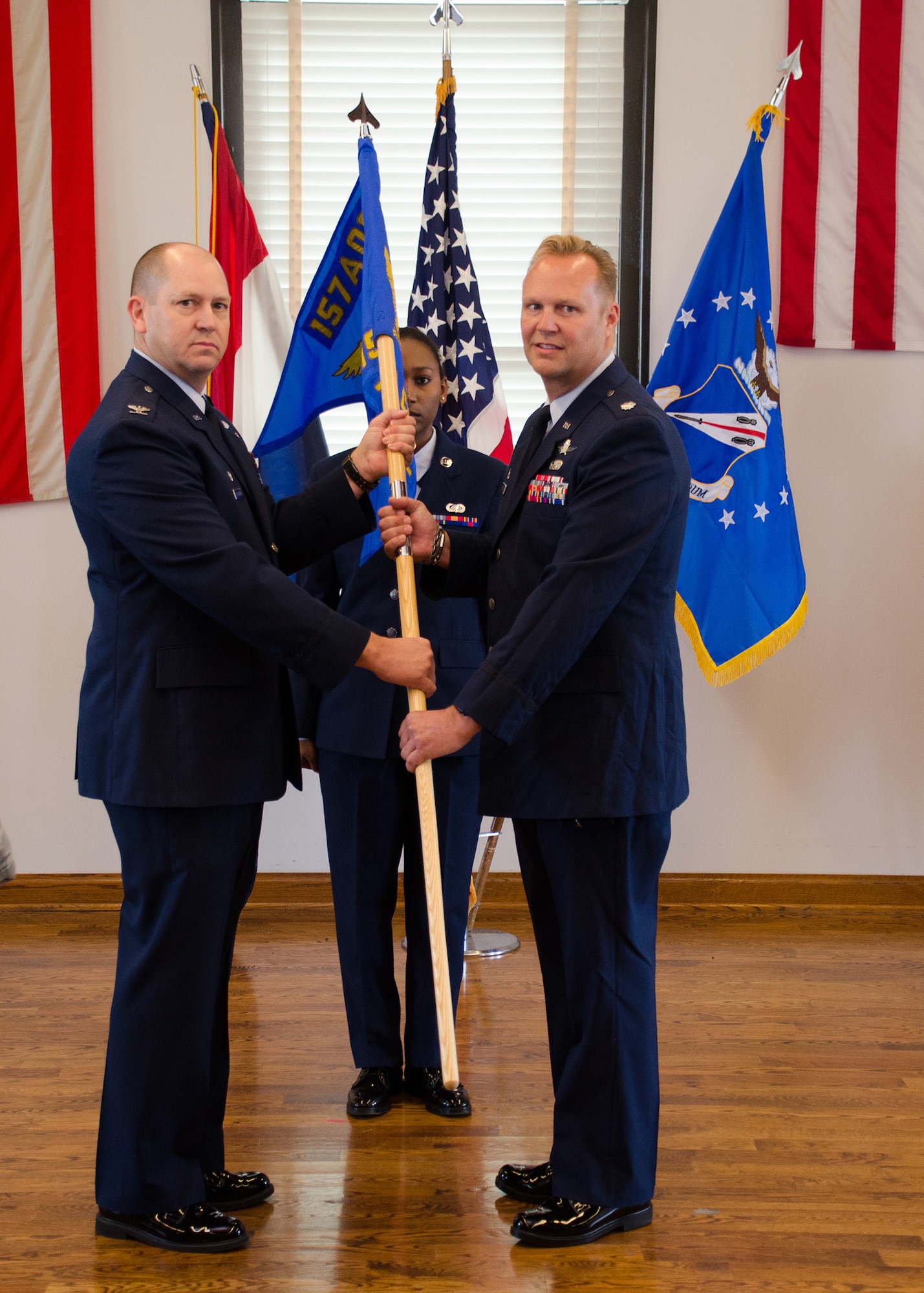 Col. William Boothman, 157th Air Operations Group commander, hands the unit guidon, and with it, leadership authority, to Lt. Col. Thomas Bischoff, 157th Air Communications Squadron commander, at Jefferson Barracks Air National Guard Base, Missouri, during drill Nov. 5, 2016. Three new commanders took charge of three new squadrons -- the 157th ACS, the 157th Air Intelligence Squadron and the 157th Combat Operations Squadron, new units of the 157th AOG -- at a single assumption of command ceremony. (U.S. Air National Guard photo by Staff Sgt. Brittany Cannon)