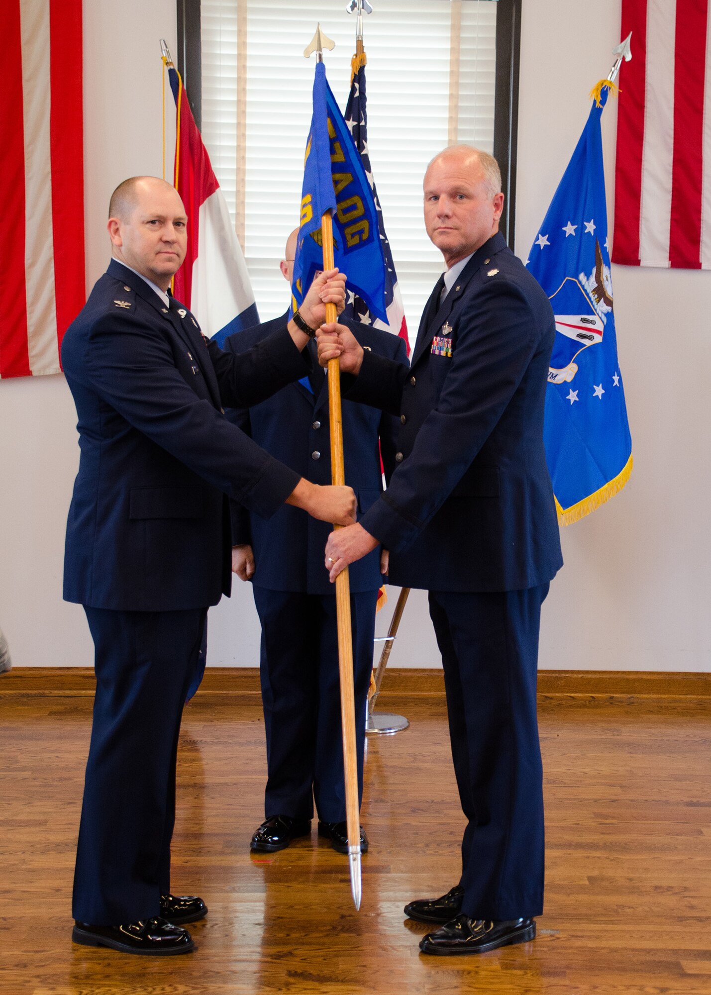 Col. William Boothman, 157th Air Operations Group commander, hands the unit guidon, and with it, leadership authority, to Lt. Col. James Hendren, 157th Combat Operations Squadron commander, at Jefferson Barracks Air National Guard Base, Missouri, during drill Nov. 5, 2016. Three new commanders took charge of three new squadrons -- the 157th COS, the 157th Air Intelligence Squadron and the 157th Air Communications Squadron, new units of the 157th AOG -- at a single assumption of command ceremony. (U.S. Air National Guard photo by Staff Sgt. Brittany Cannon)