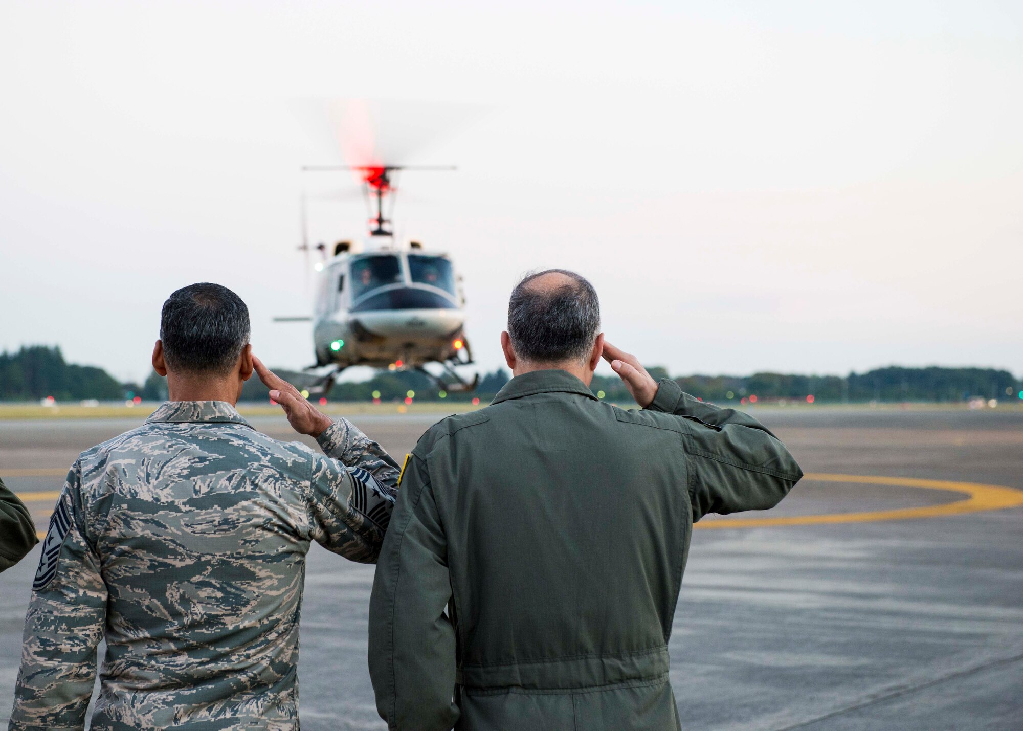 U.S. Air Force Chief Master Sgt. Terrence A Greene, United States Forces Japan and 5th Air Force command chief, and Lt. Gen. Jerry P. Martinez, USFJ and 5th AF commander, salute USAF Chief of Staff Gen. David L. Goldfein as he takes off in UH-1 Iroquois helicopter on Nov. 5, 2016, at Yokota Air Base, Japan. Goldfein visited Yokota Air Base to communicate his focus areas of revitalizing squadrons, strengthening joint leaders and teams, and multi-domain command and control. (U.S. Air Force photo by Airman 1st Class Donald Hudson/Released)