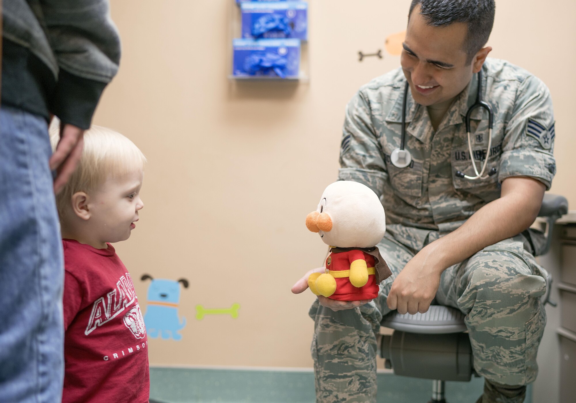 Senior Airman Edward Checkcinco, 374th Medical Group medical technician, shares a toy with a patient on Nov. 2, 2016, at Yokota Air Base, Japan. Yokota’s pediatrics clinic specializes in keeping the base’s children well, from birth to young adulthood. (U.S. Air Force photo by Senior Airman Delano Scott/Released)